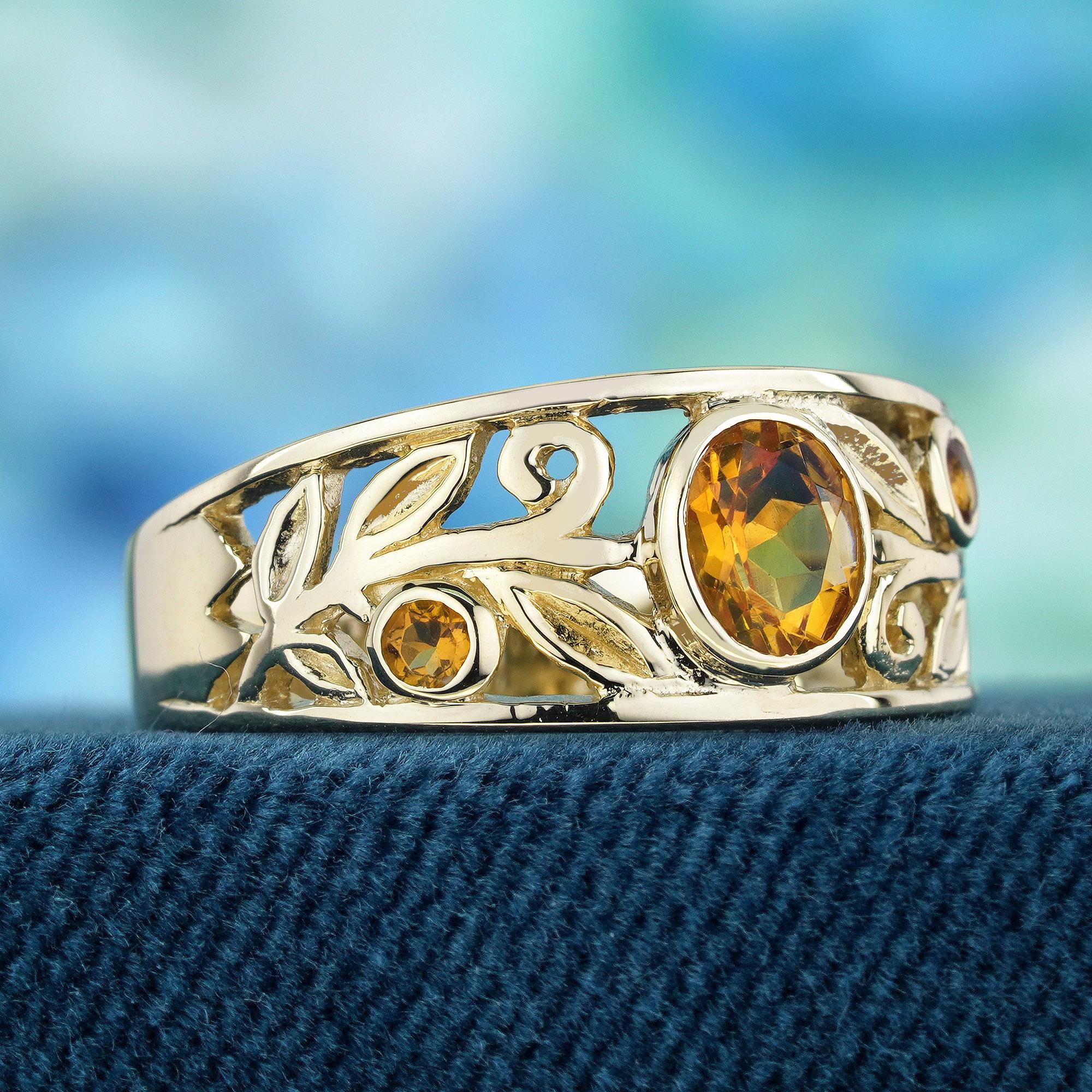 Enhance your hand with a touch of delicate elegance through this vintage-style carved band ring featuring a natural citrine gemstone in yellow gold. The wide intricately carved band showcases a charming floral and swirl design. The warm yellow