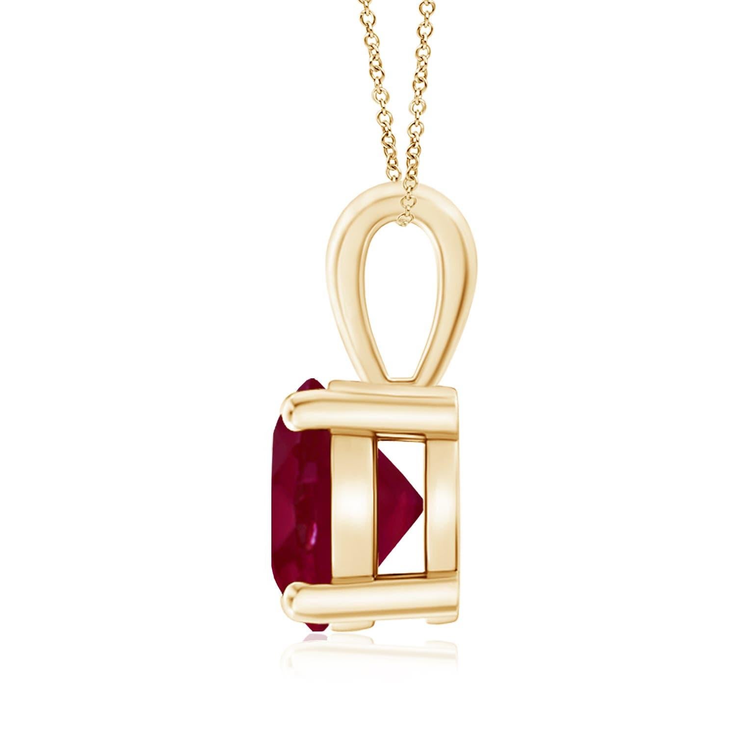 Un solitaire en rubis rouge violacé, serti dans une monture à quatre griffes, est relié à une balle lustrée. Réalisé en or jaune 18 carats, le design élégant de ce pendentif classique en rubis attire toute l'attention sur la magnificence de la