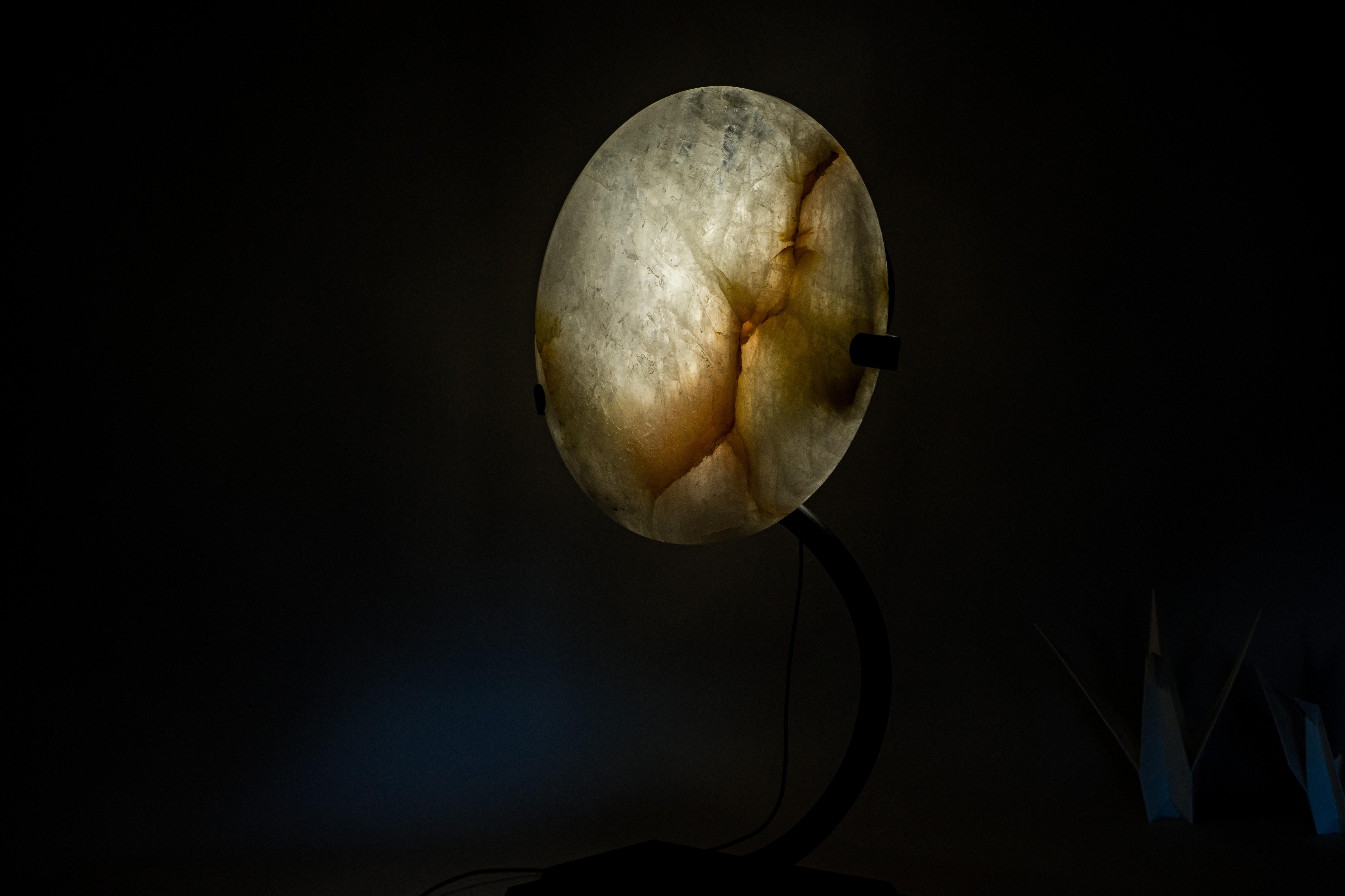 Crystal Quartz Lamp with Hematite Inclusions – Hand-sculpted Natural “Full Moon”

▫️ Description

Illuminate your space with the ethereal beauty of nature. This handcrafted quartz lamp features delicate hematite inclusions and creates a mesmerizing