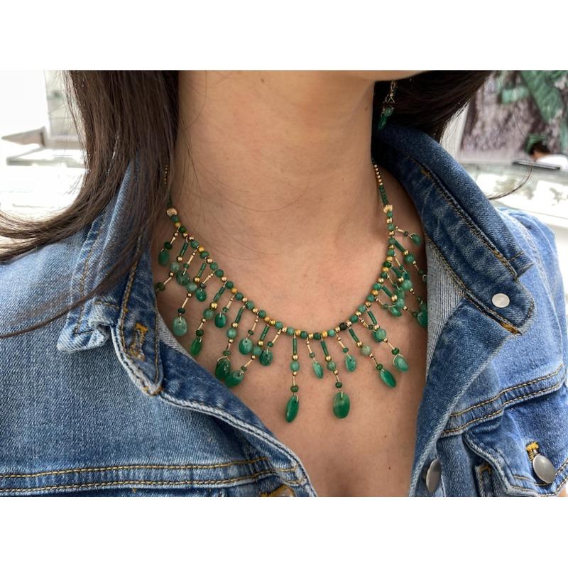 Ti presentiamo la nostra straordinaria collana con ciondolo di smeraldo naturale tagliato grezzo, ornata da perline multiple di smeraldo tagliato rotondo e smeraldi ovali cabochon di forma irregolare, disposti in un motivo accattivante. Grazie alla