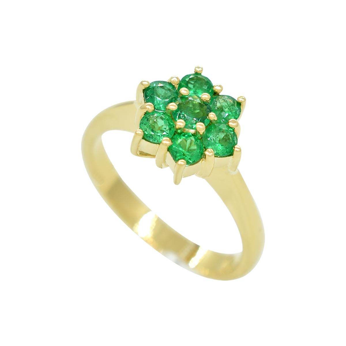 Emerald ring custom made in 18K yellow gold with a beautiful selection of 7 round cut natural emeralds from Colombia in 0.65 carats total weight, in a stunning cluster ring design. All the gemstones share a gorgeous “grass green” color full of life