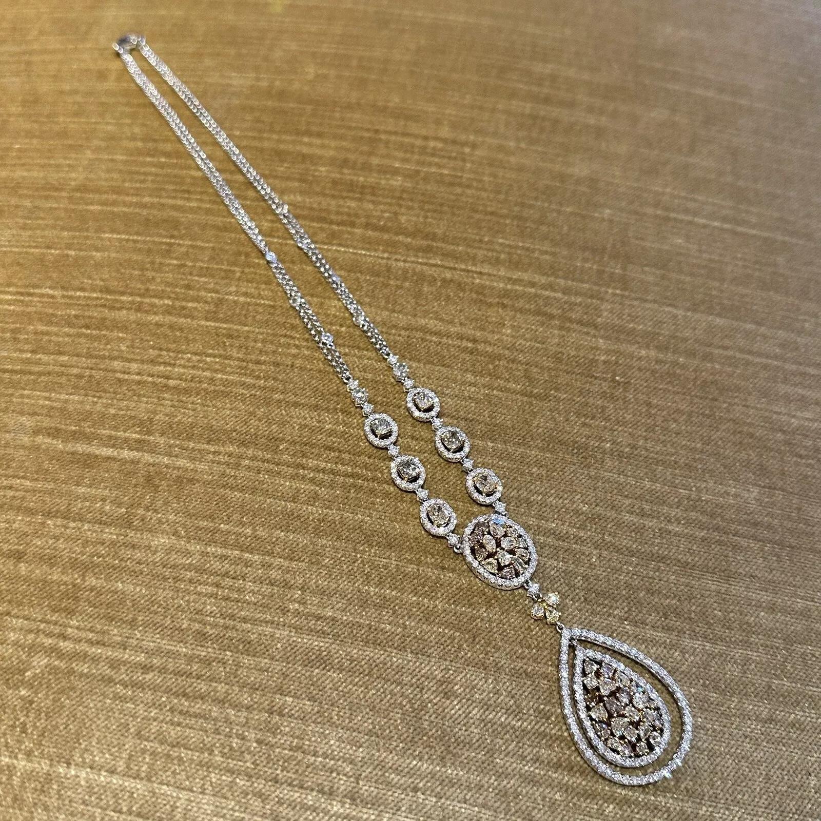 Collier pendentif en or blanc et jaune 18 carats 

Le collier de diamants présente des grappes de diamants de couleur Nature de formes variées entourées de diamants ronds blancs de taille brillant avec des diamants de taille ovale, coussin, ronde et