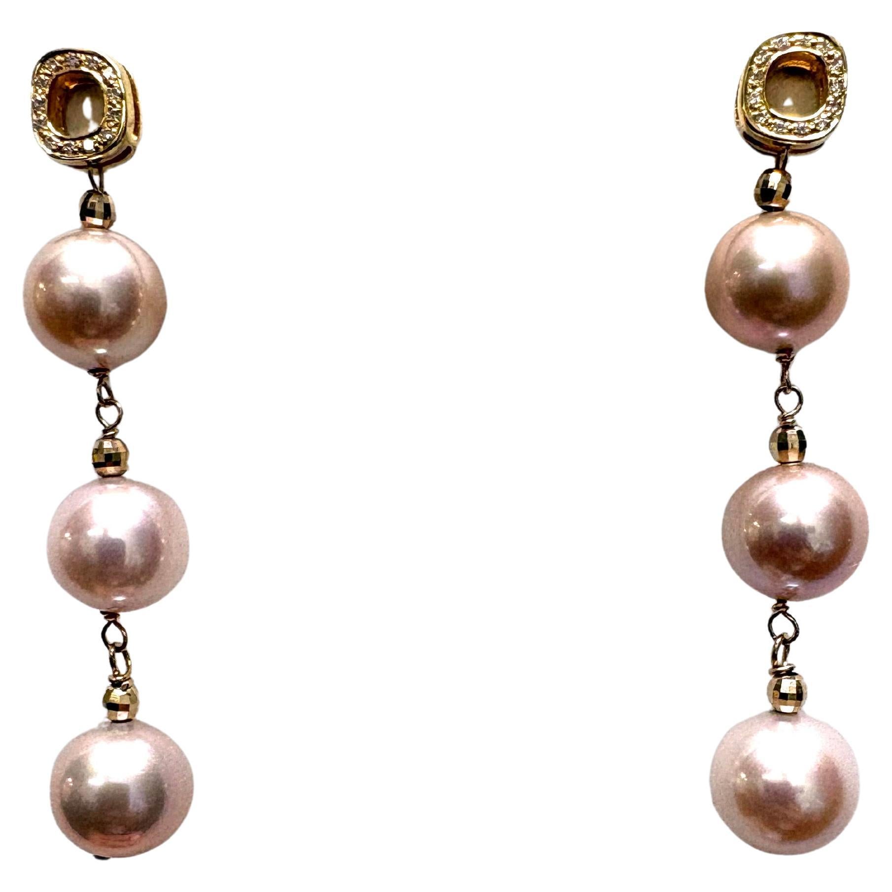 Descripción
Radiantes e impecables, estas perlas de agua dulce de un suave tono rosa natural, coronadas cada una de ellas con una cuenta facetada de oro de 14k, cuelgan con gracia bajo unas patillas irregulares de oro amarillo de 18k con diamantes,