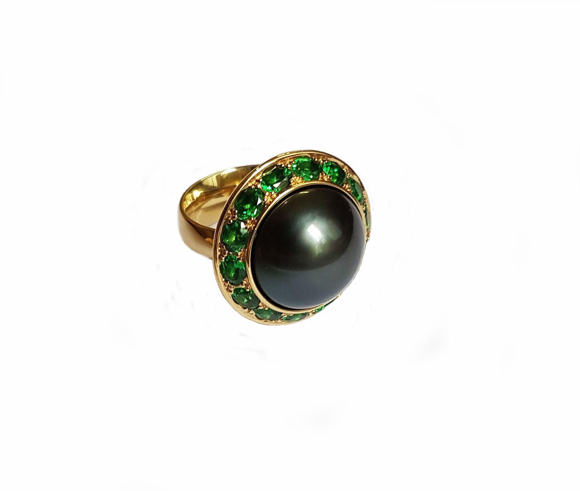 This gorgeous ring is made of 750/0 yellow gold and features an opulent natural colored Tahitian pearl of 16 mm with excellent luster, surrounded by 12 tsavorites with a total of 3.11 carats. 
This ring would make a spectacular gift that can be worn