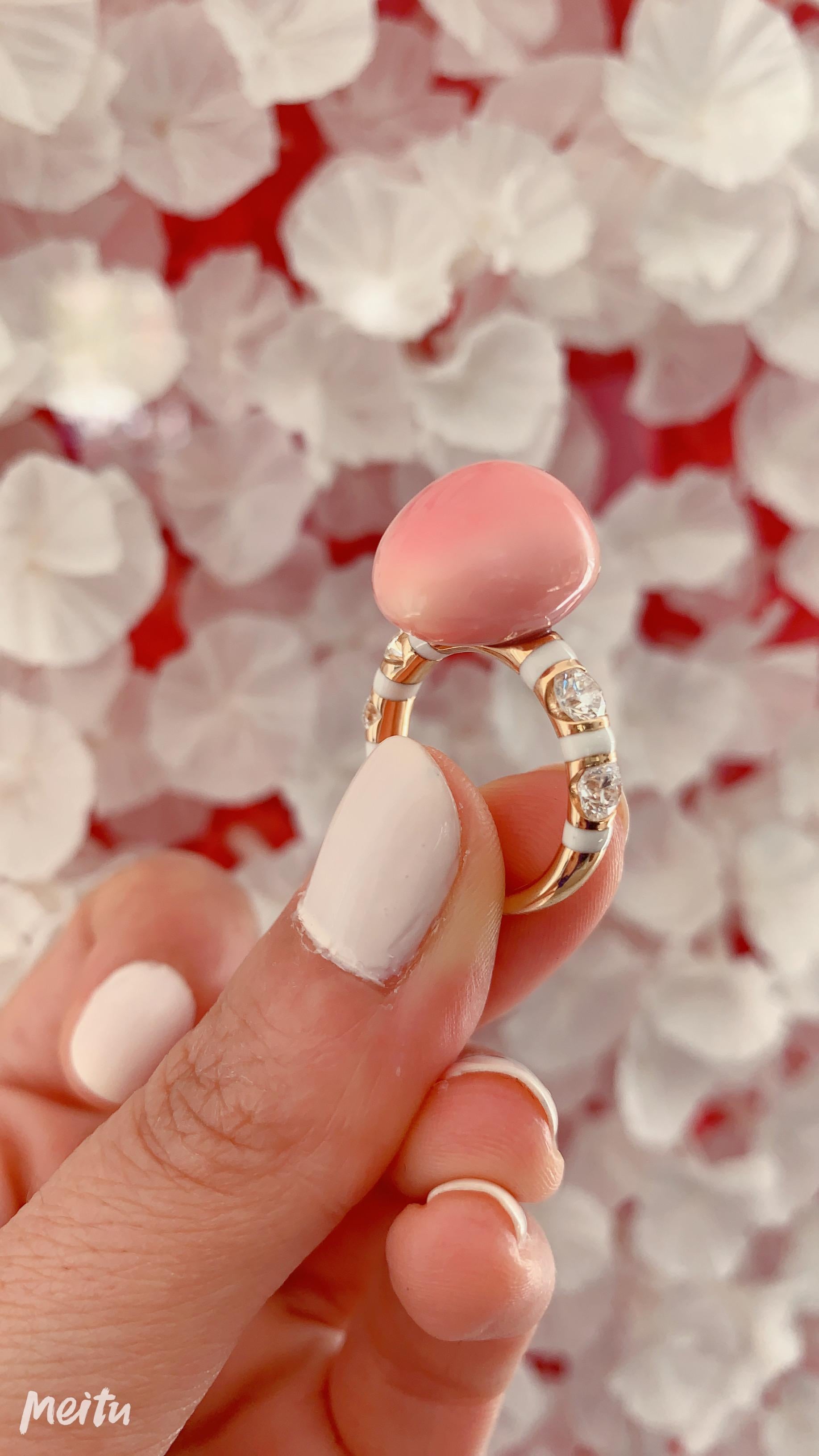 A Pink Conch Pearl, Diamond and Enamel Gold Ring in the Candy Collection by Jewelry Designer, Sarah Ho.

This 17.75ct pink conch pearl is set between four tension set F VS diamonds of total 1.06ct in an 18kt rose gold ring with white enamel bands.