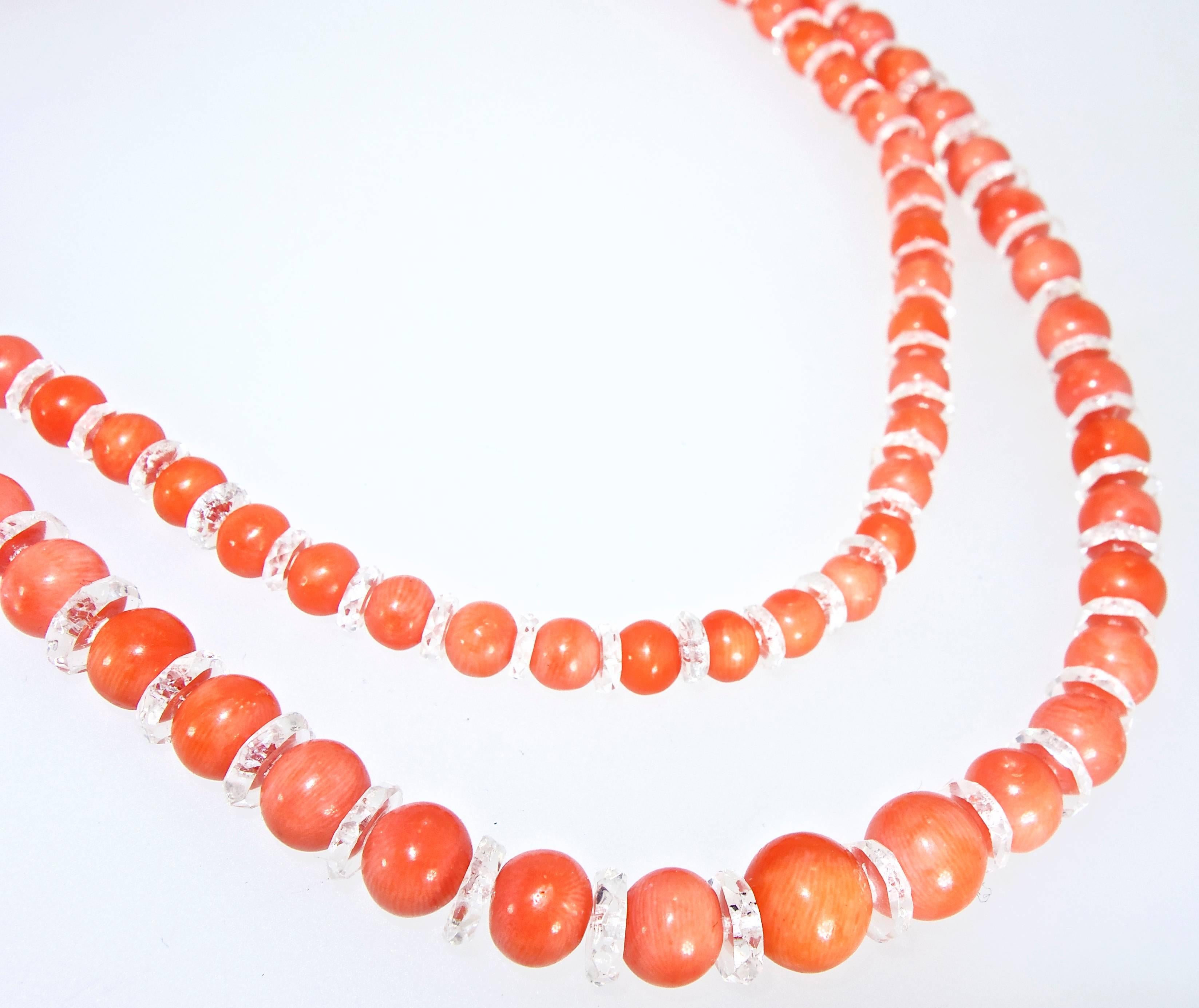 Natural coral measuring 8.74 mm to 5.35 mm, this coral is a medium bright orange color and is over 32 inches long.  Accenting the well match coral beads are faceted natural rock crystal roundels and this necklace is finished with an early 14K white