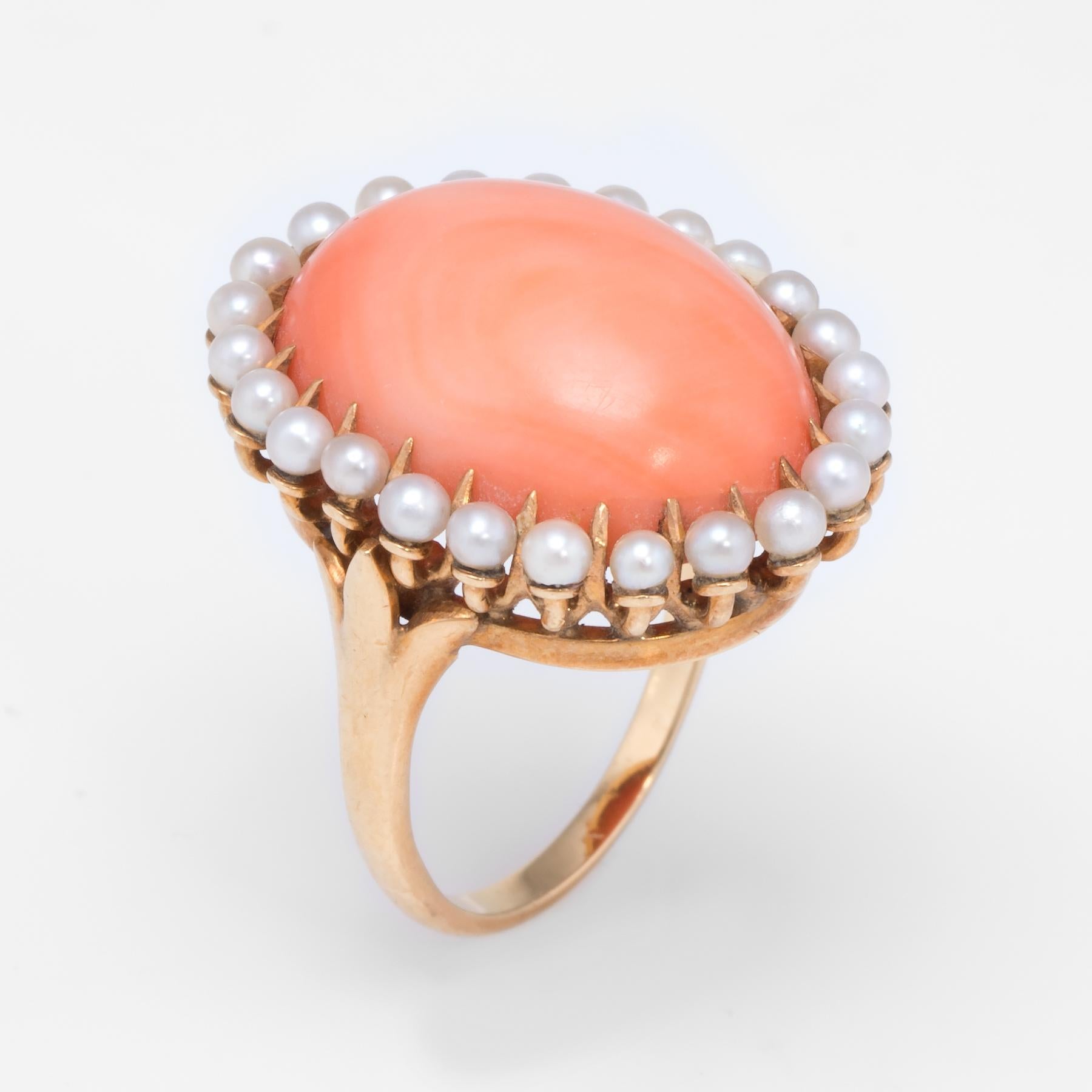 Elegant vintage cocktail ring (circa 1940s to 1950s), crafted in 14 karat yellow gold. 

Centrally mounted cabochon cut coral measures 18mm x 13mm (estimated at 8 carats), accented with 1.5mm seed pearls. The coral is in excellent condition and free