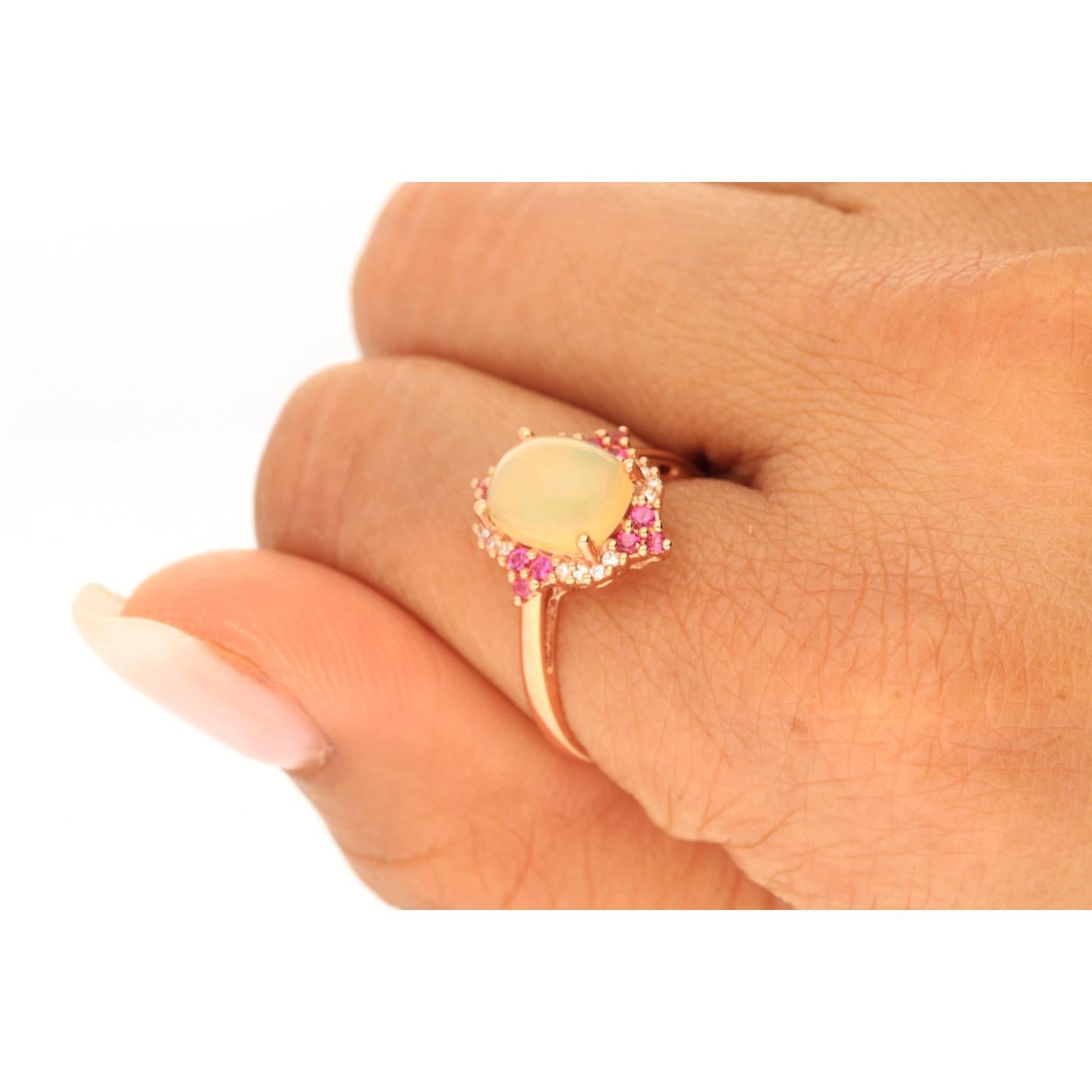 This beautiful Natural Opal Ring is crafted in 10-karat Yellow gold and features a 1.41 carat 1 Pc Natural Ethiopian Opal, 12 Pcs Round Cut Hot Pink Ruby with 0.24 Carats and 16 Pcs Round White Diamonds in GH- I1 quality with 0.06 Ct in a