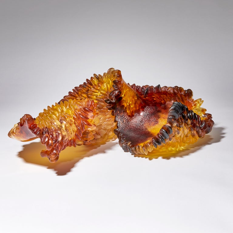 Natural deviations is a unique textured cast glass sculpture in amber, red and brown by the British artist Nina Casson McGarva.

Casson McGarva firstly casts her glass in a flat mould where she introduces all of the beautifully detailed, scaled