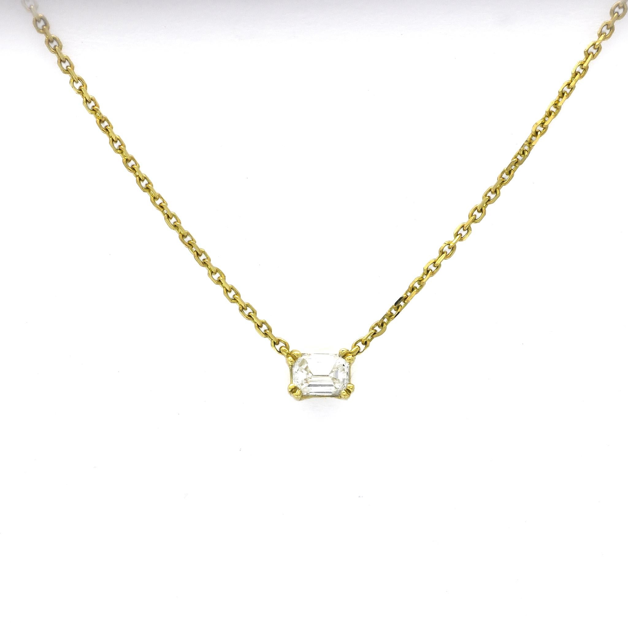 This exquisite piece of jewelry is a testament to the timeless allure of simplicity and elegance. Suspended from an 18-karat yellow gold chain, the focal point of this necklace is a mesmerizing emerald-cut natural diamond weighing 0.16 carats. The