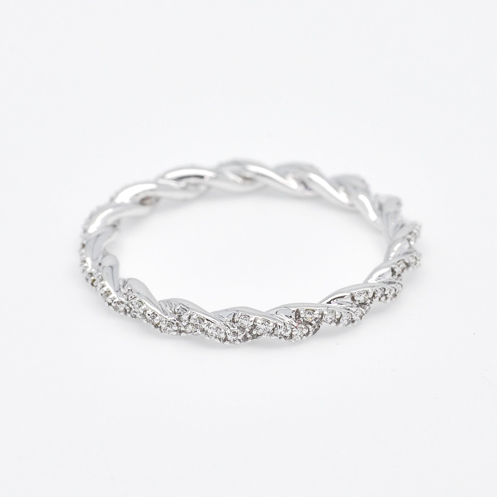 true masterpiece fashioned from lustrous 18k white gold. This stunning ring showcases a continuous band of meticulously set round-shaped diamonds, totaling an impressive 0.25 carats. Each diamond has been carefully selected for its exceptional