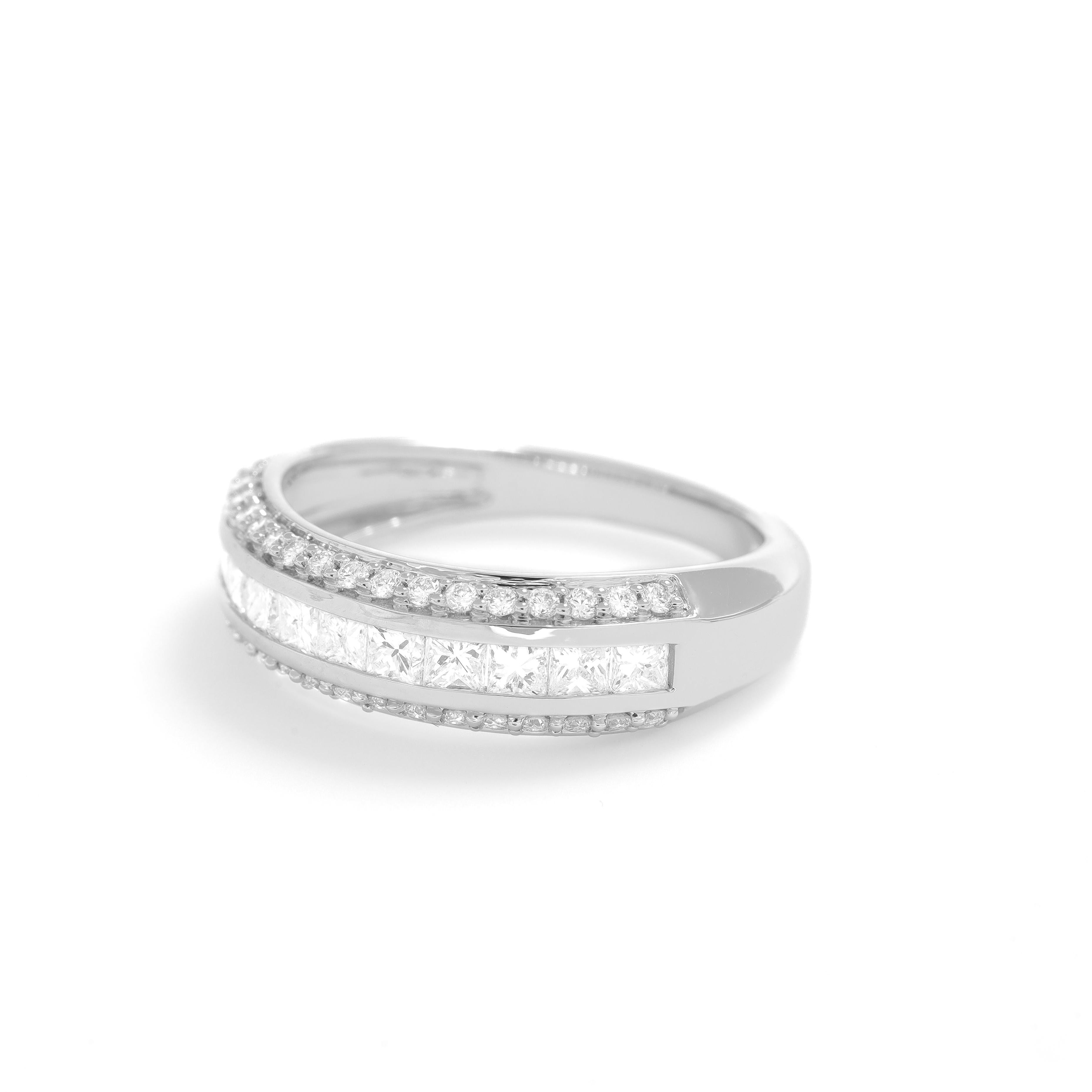 Immerse yourself in the allure of this exquisite piece, where timeless elegance meets modern design. This stunning ring features a row of captivating Princess-shaped diamonds, delicately nestled between two rows of round brilliant cut natural
