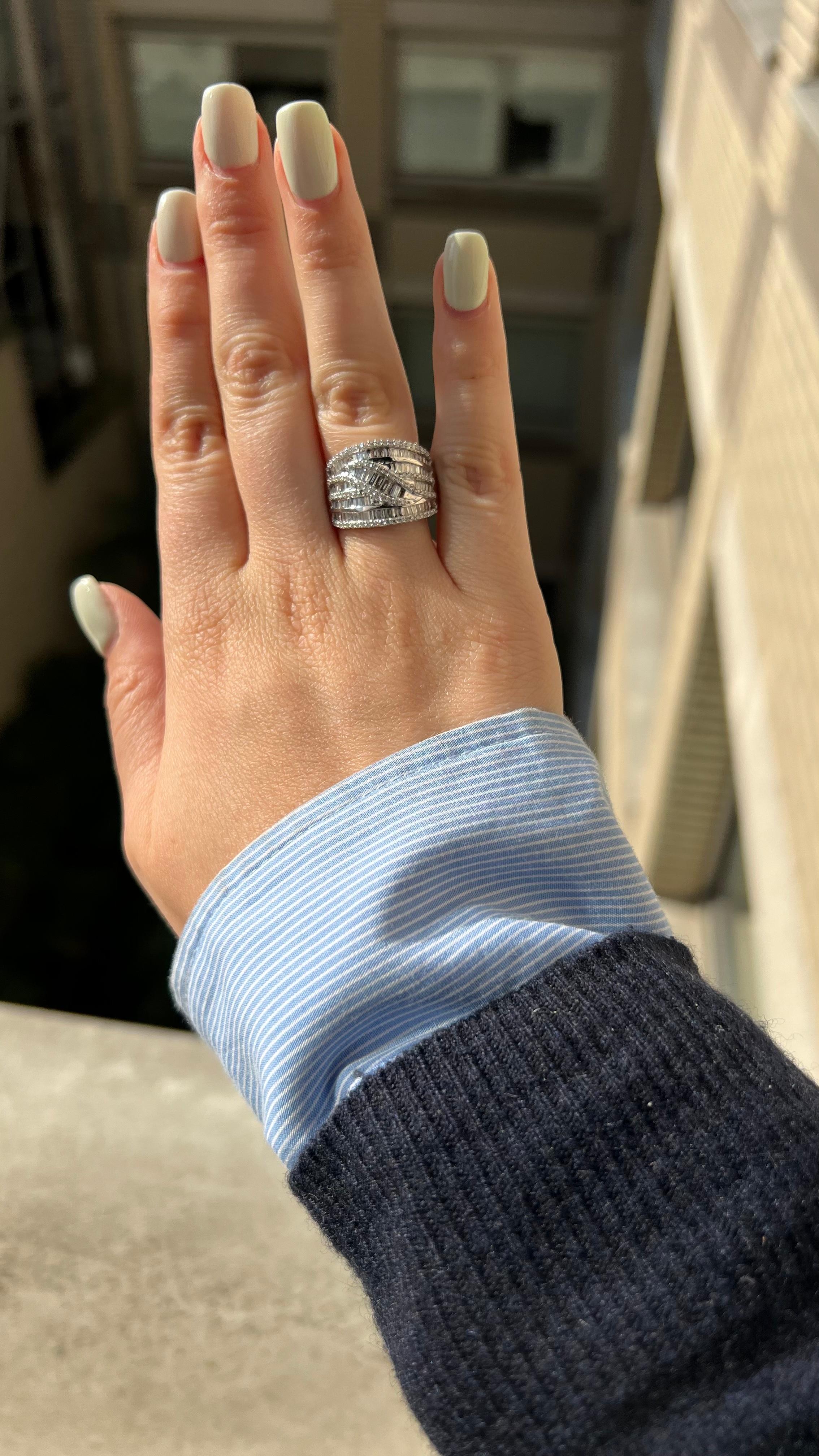 Audaci incastonature geometriche di diamanti rotondi e baguette conferiscono uno scintillio che cattura la luce da ogni angolazione di questo anello in oro bianco. 

Questo design conferisce all'anello una forma sinuosa, che viene ulteriormente