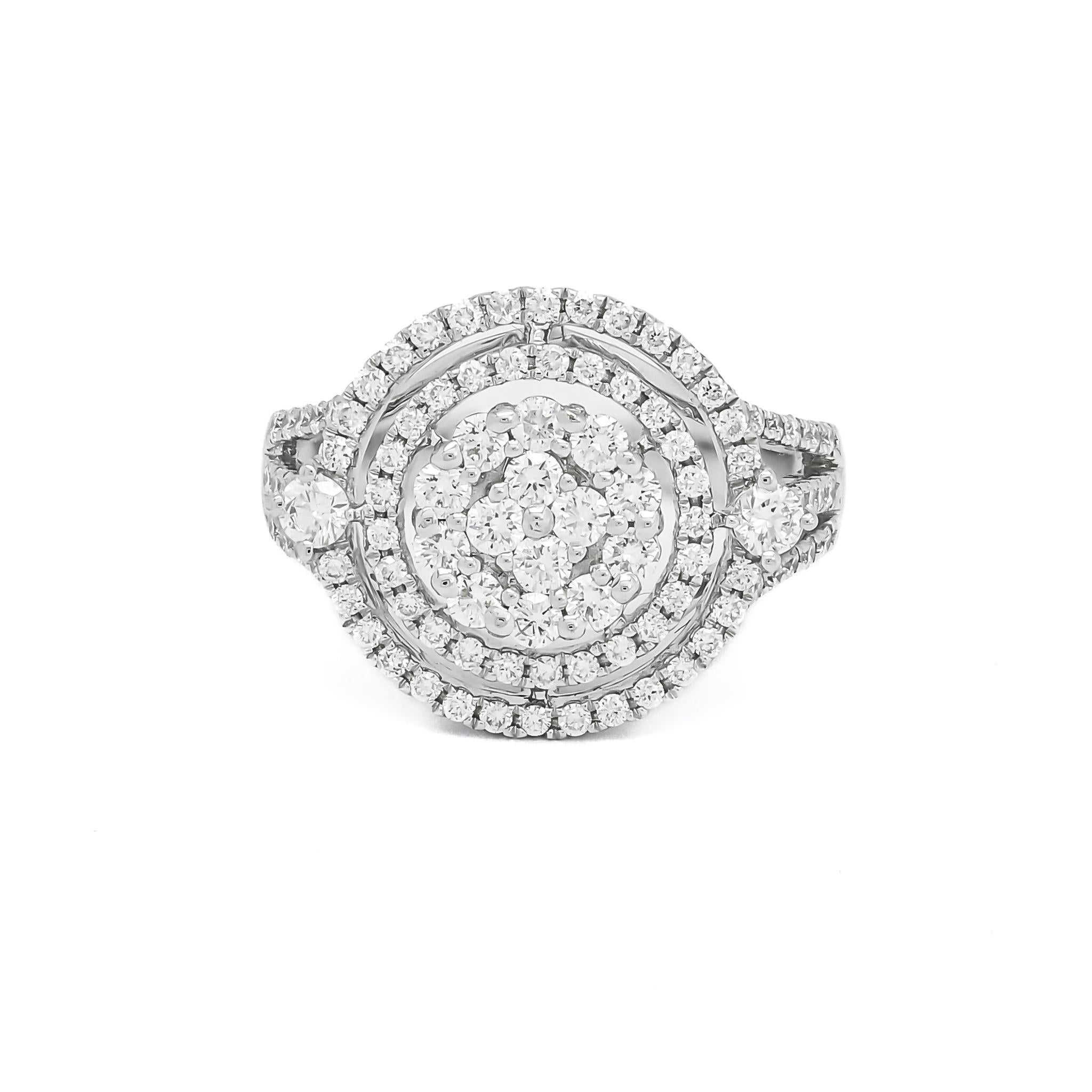 L'éblouissement et le drame se conjuguent dans cette étonnante bague de fiançailles à double halo de diamants, véritable témoignage de compétence et d'artisanat en or blanc 18 carats. Cette bague exquise présente une grappe de diamants centraux de