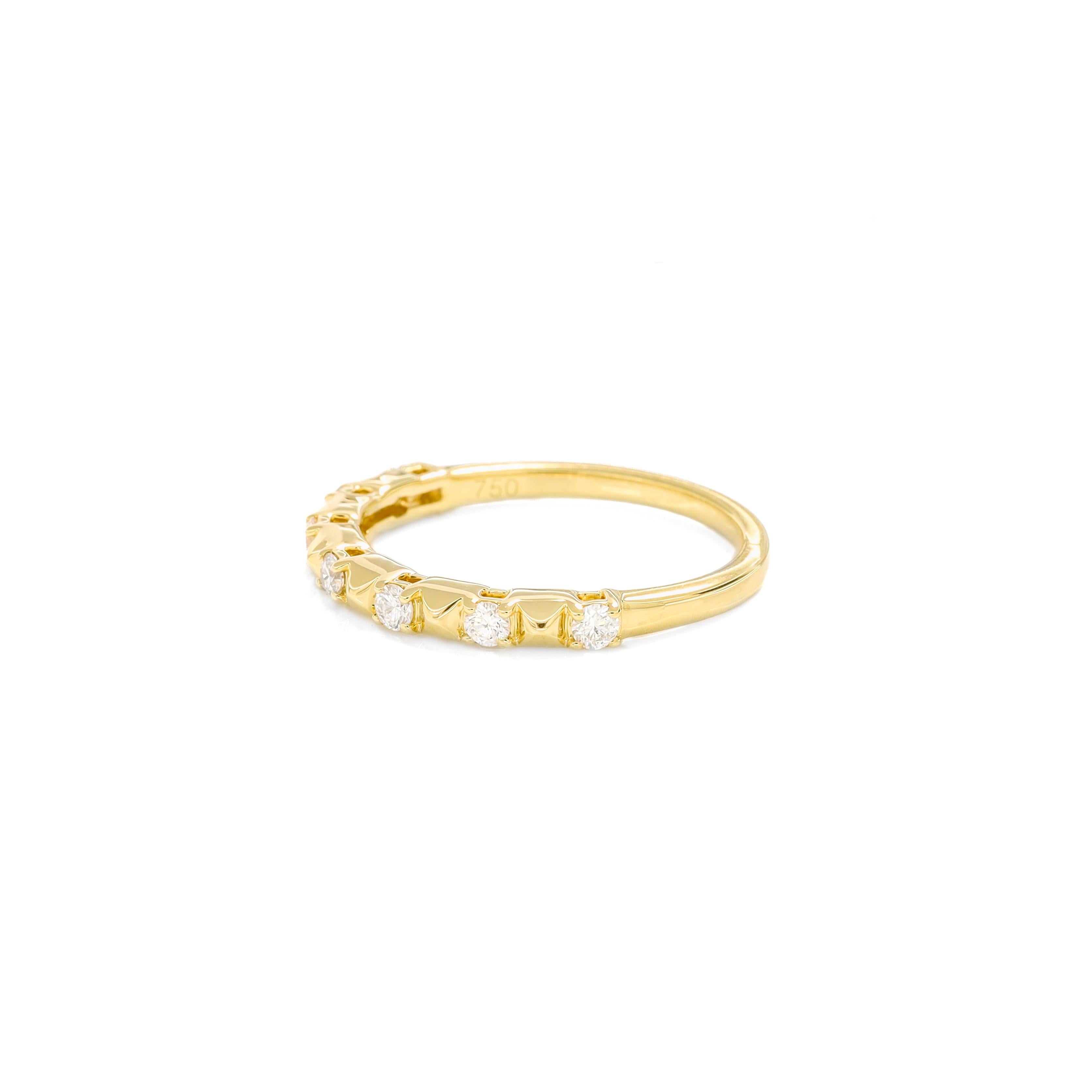 Das Herzstück des Rings ist eine Reihe runder Diamanten von insgesamt 0,25 Karat, die sorgfältig in die reiche Umarmung aus 18-karätigem Gelbgold gefasst sind. Die Zwischenräume zwischen den Diamanten sind mit texturierten Goldperlen verziert, die