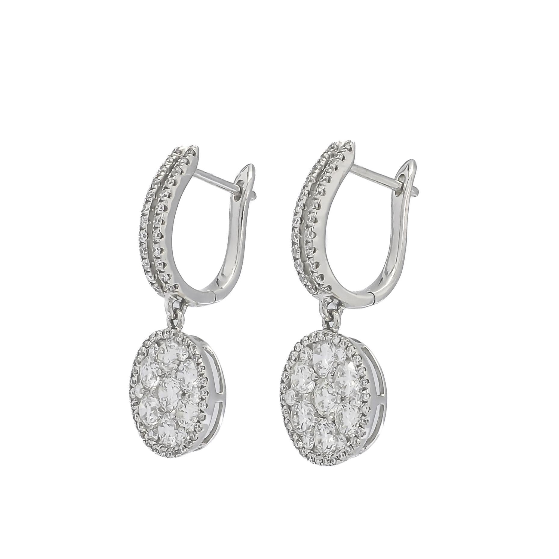 A captivating combination of round natural diamonds takes center stage, expertly arranged in a halo illusion setting within a graceful drop dangler, accompanied by two rows of diamond Huggies. This meticulously crafted ensemble is a true testament
