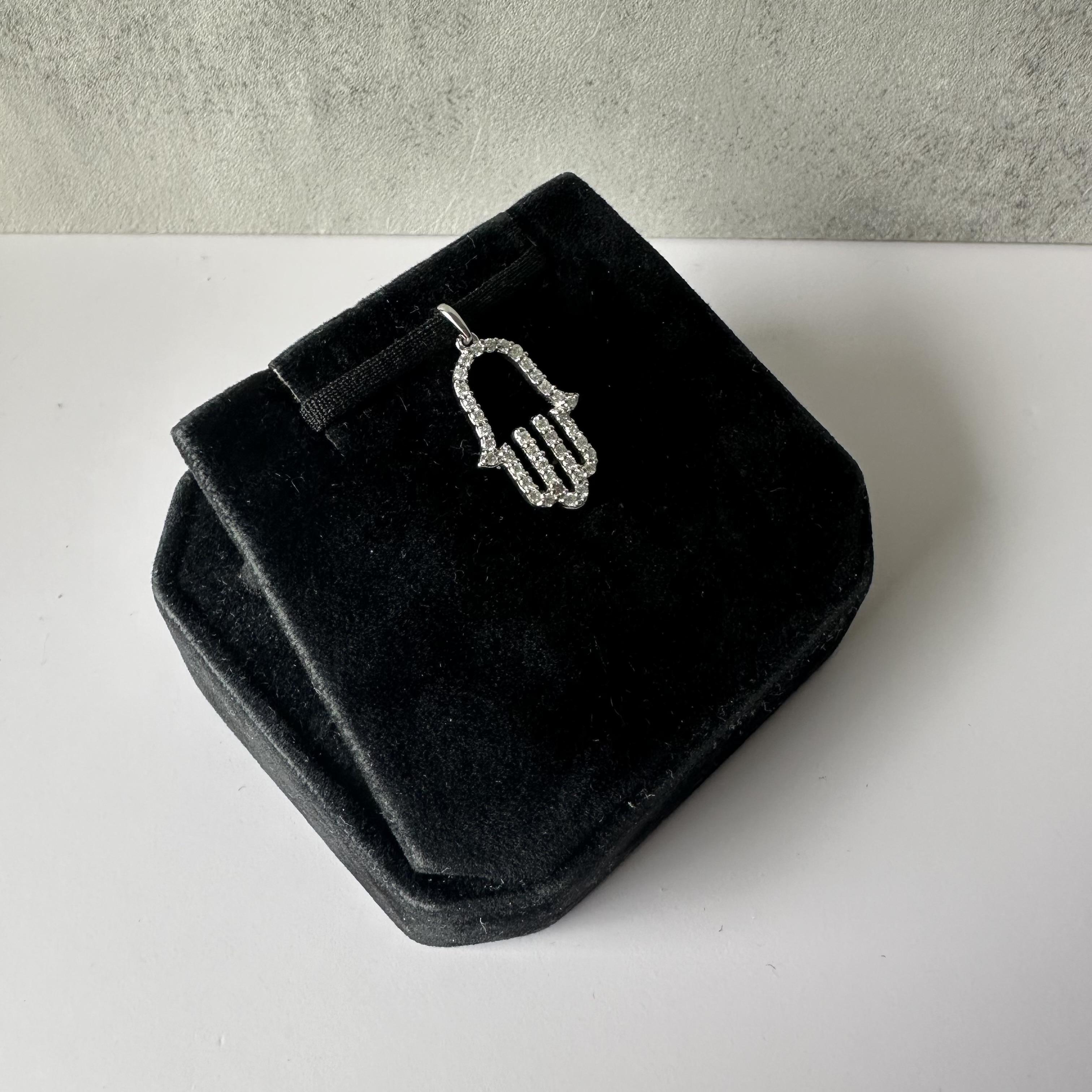 Eleganza e protezione senza tempo con questo ciondolo Natural Elegance Hamsa, realizzato in oro bianco 14 carati. L'Hamsa, simbolo di fortuna e protezione, è ornato da 0,33 carati di diamanti naturali di colore HI con purezza SI2-I1, che aggiungono