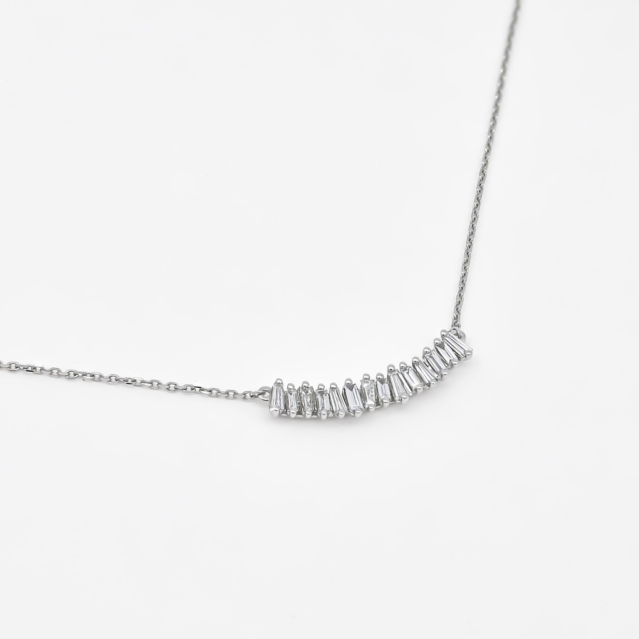 The baguette diamonds in this cluster pendant necklace are expertly cut and meticulously arranged to create a harmonious balance of shapes and angles. The elongated rectangular shape of the baguette diamonds adds a touch of modernity and