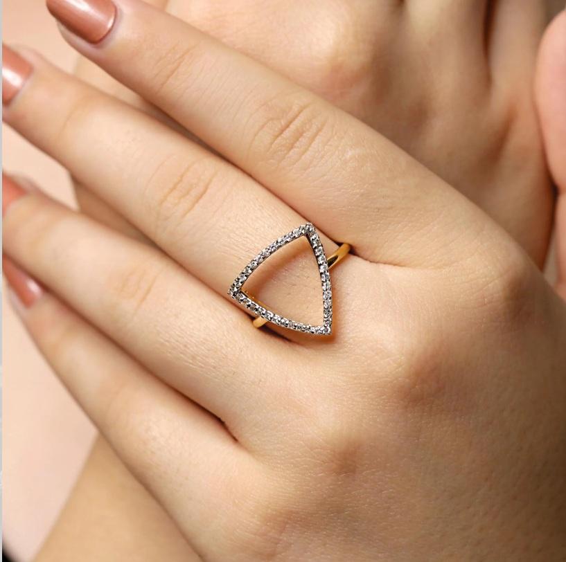 Questo splendido anello di fidanzamento con diamante è realizzato in pregiato oro giallo 14K e presenta un'incastonatura di diamanti rotondi. Il diamante centrale con taglio a brillante dell'anello è incastonato in una montatura a quattro punte ed è