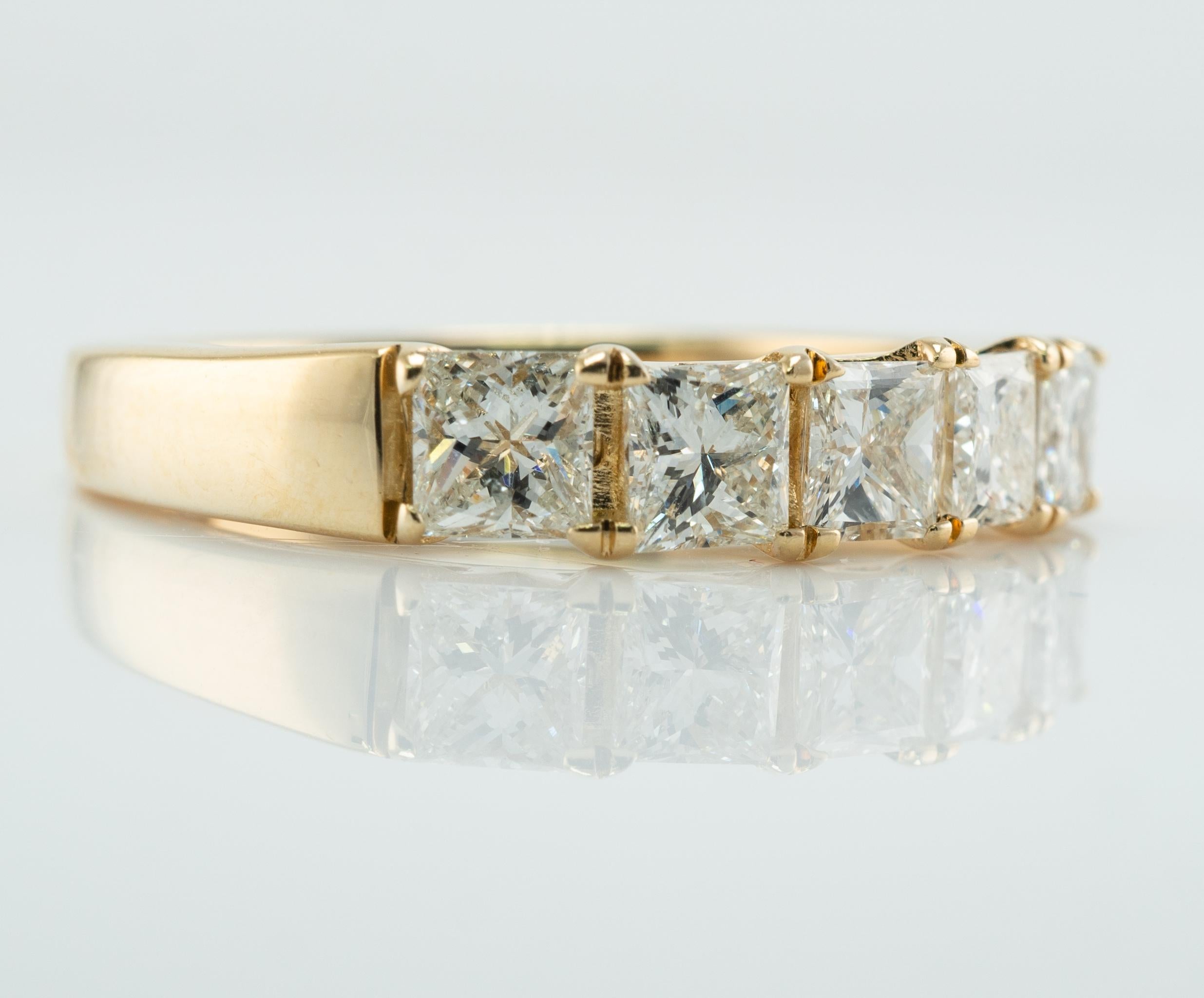 Natural Diamond Ring Princess cut 14K Gold Band 1.34 cttw

This estate ring is crafted in solid 14K Yellow Gold.
Five princess cut diamonds total 1.30 carats of VS2 clarity and G color.
One round diamond is set inside of the shank. This is a .04