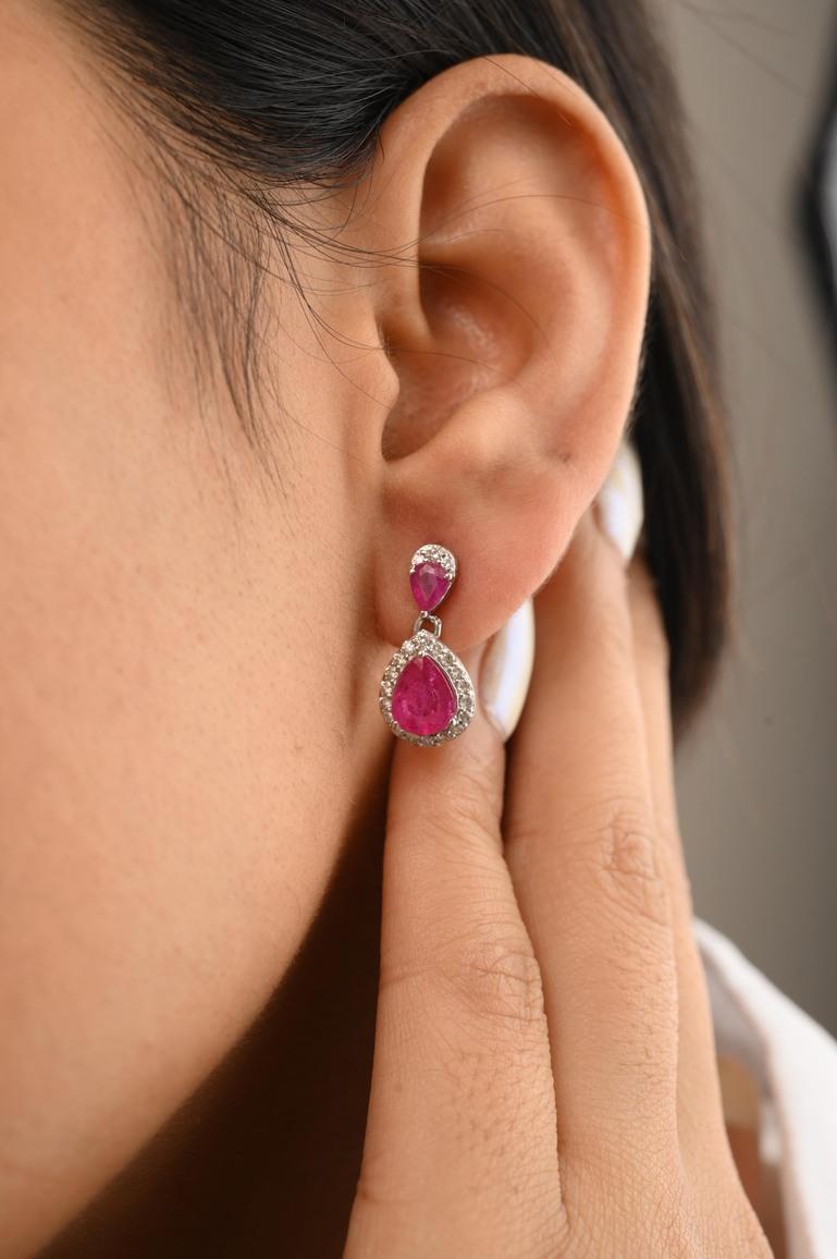 Natural Diamond Ruby Dangle Earrings in 14K Gold to make a statement with your look. You shall need stud earrings to make a statement with your look. These earrings create a sparkling, luxurious look featuring pear cut ruby and round cut