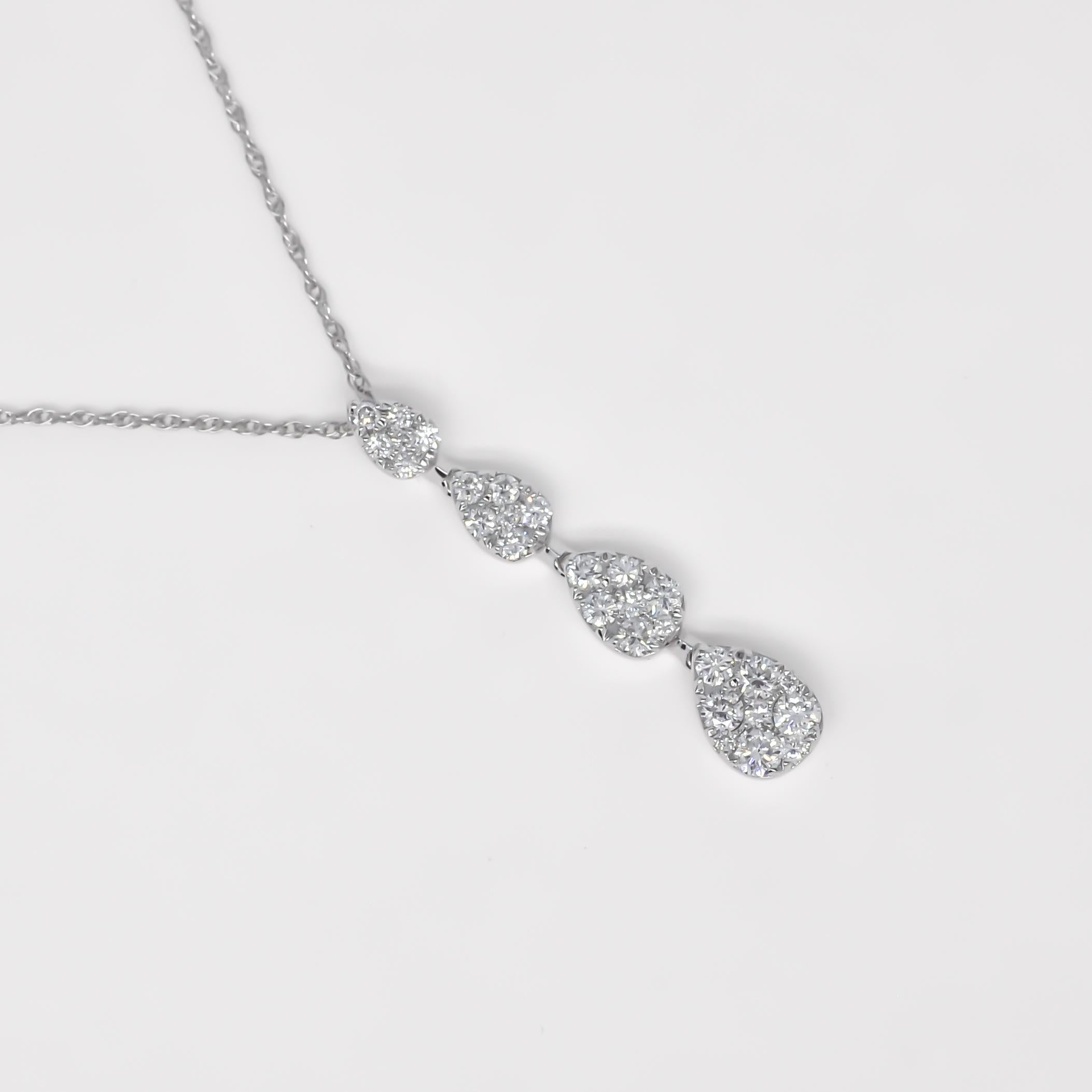 Unsere Graduating Diamond Cluster Drop Pendant Necklace ist der Inbegriff von Raffinesse und Charme. Dieses bemerkenswerte Schmuckstück zeigt vier Gruppen natürlicher, runder Diamanten, von denen jede sorgfältig angeordnet ist, um eine fesselnde und