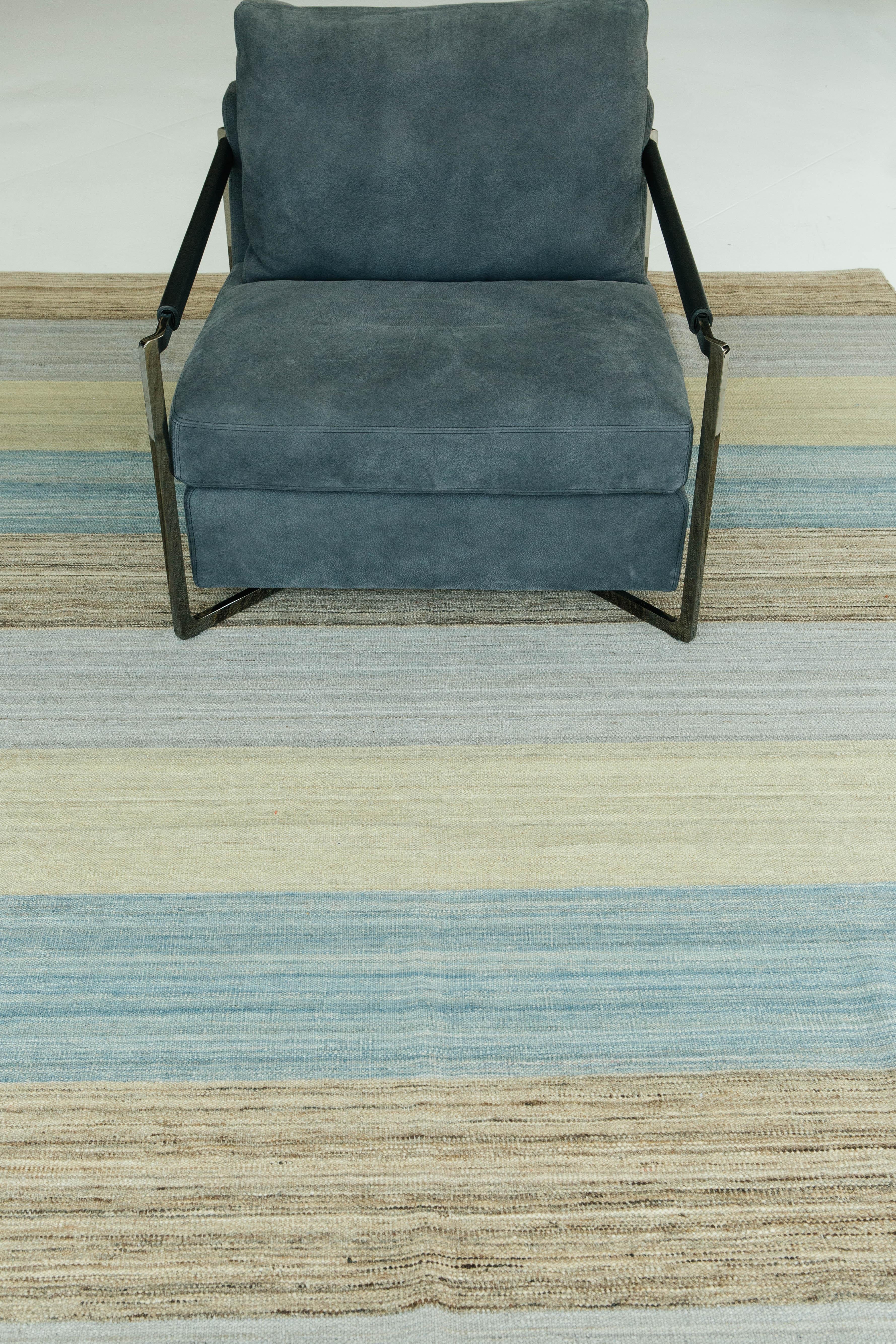 A natural dye flat-weave Kilim in crisp sage, soft blue, brown, and gray. These colors are spun into an alternating stripe pattern that work together to create a soft and soothing vibe. The Puro Collection features contemporary designs handmade by