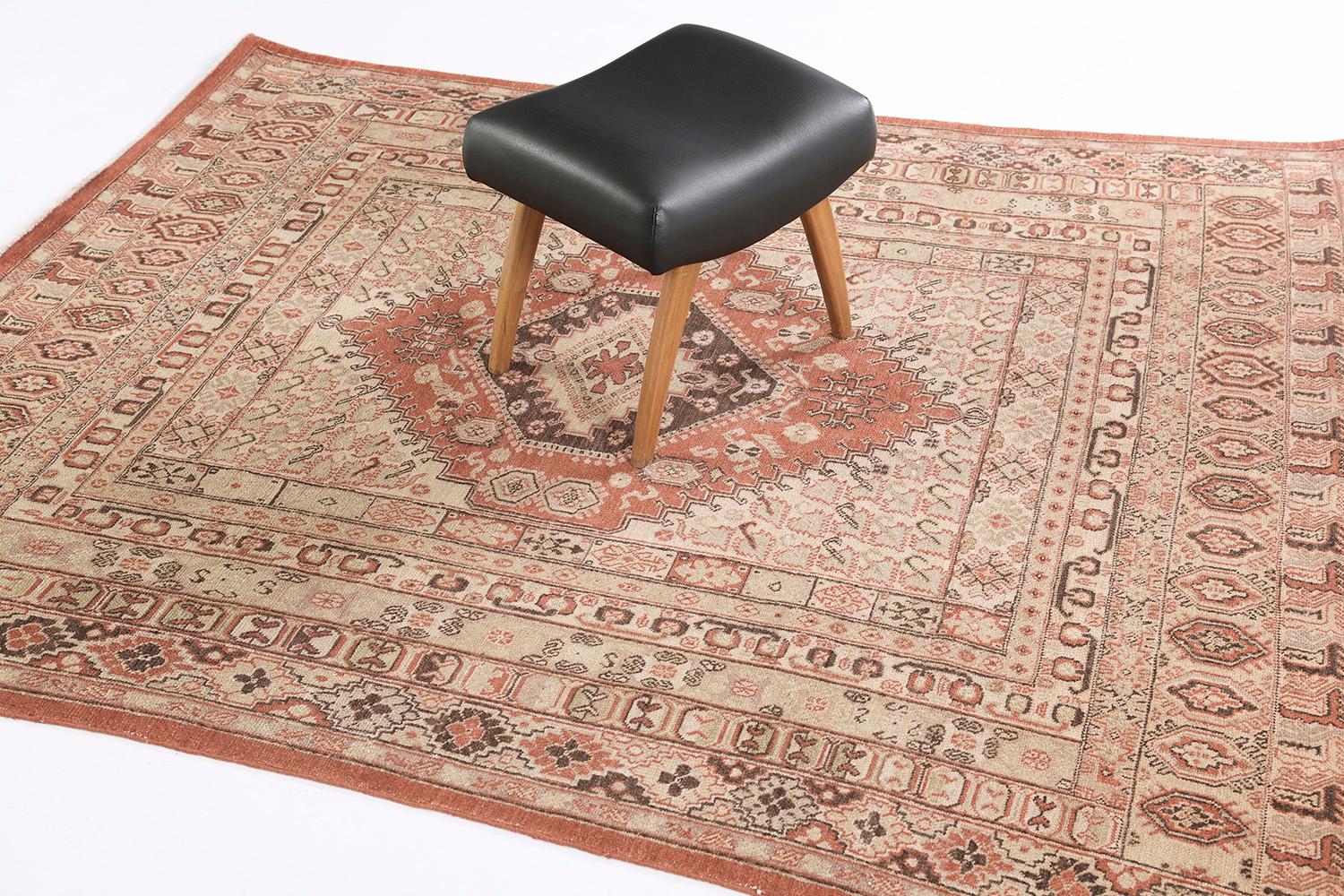 A stylishly luxurious hand-spun wool Gashgai style rug has immensely flexed its series of bands along the perimeter of emblems. It is surrounded by different kinds of intricate symbols and geometric motifs. The rust color scheme is perfect for a