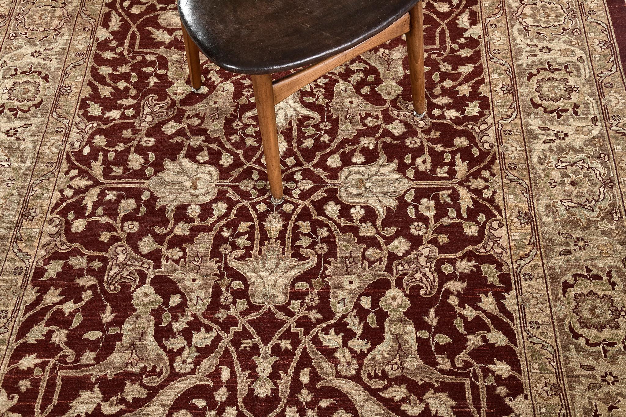 A vibrant revival of Gordes design rug that features the majestic tones of dark ruby red and ivory. The abrashed field is covered with all-over pattern composed of floral sprigs, blooming palmettes, sickle leaves, stylized florals and leafy
