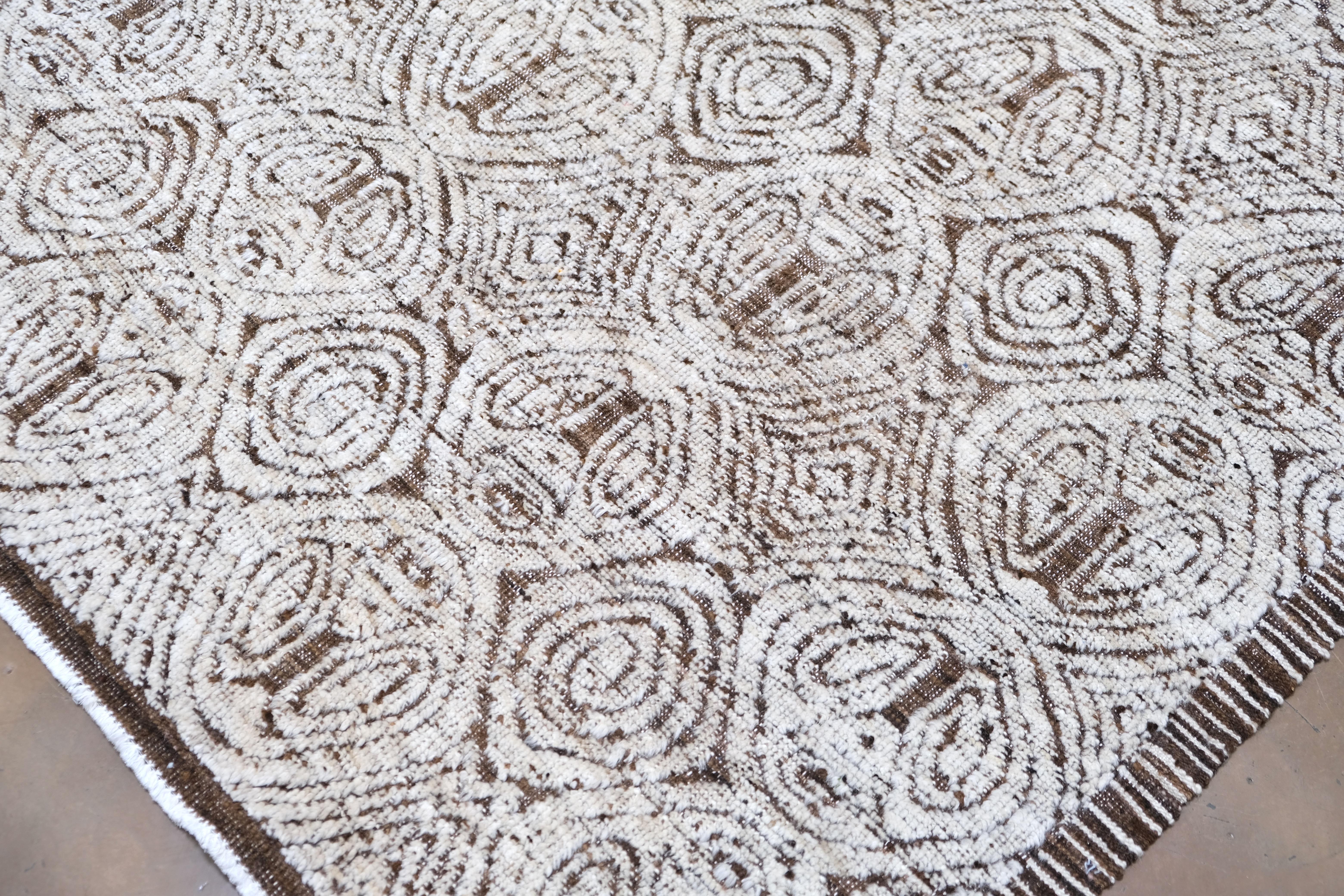 Dieser exquisite, handgeknüpfte Wollteppich aus Pakistan verbindet die Kunstfertigkeit traditioneller Handwerkskunst mit einem kühnen, modernen geometrischen Design. Mit einer Größe von ca. 9'2