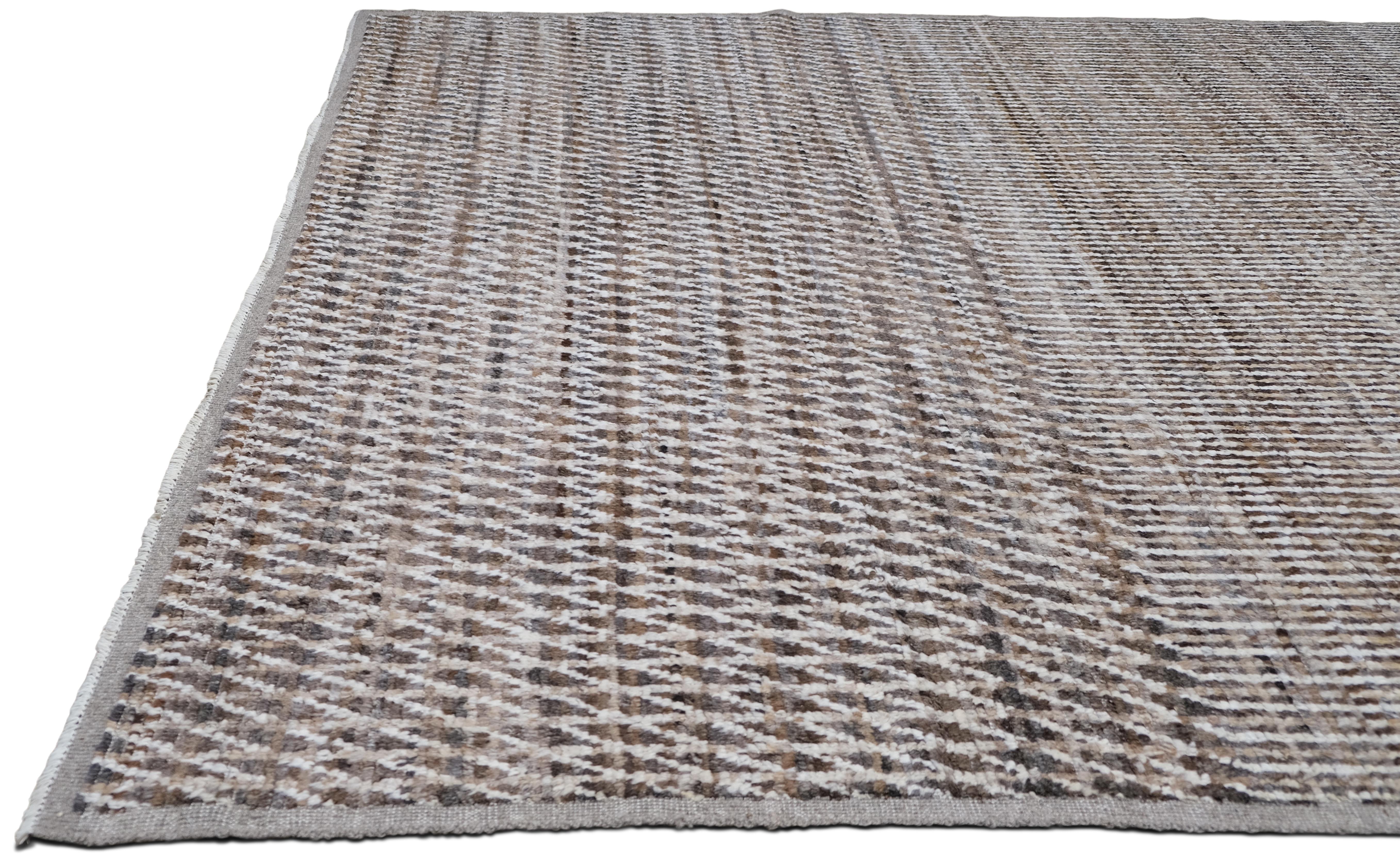 This hand-knotted wool rug is a testament to modern sophistication and expert craftsmanship. Measuring approximately 8'2