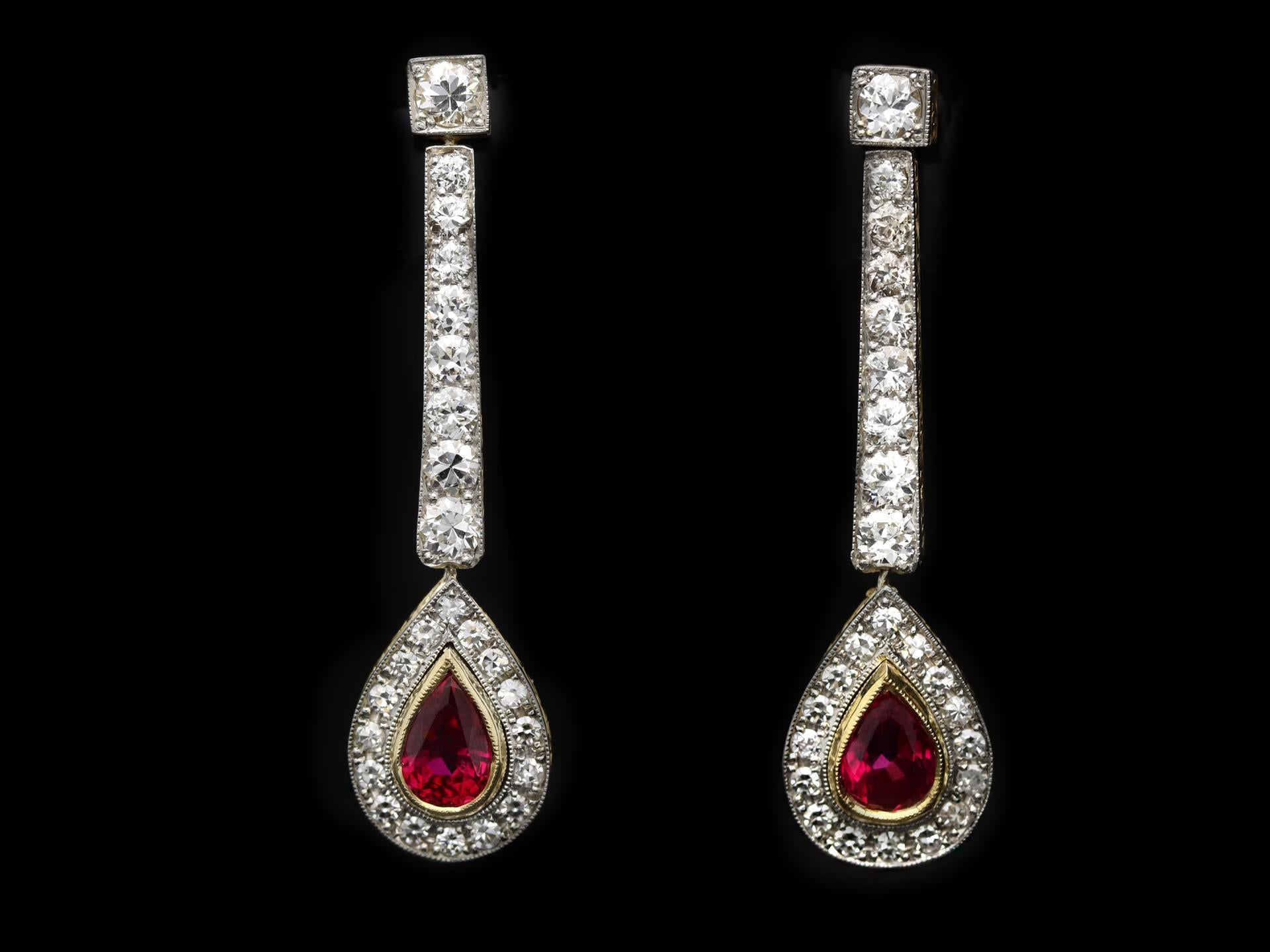 Edwardian Burmese ruby and diamond drop earrings. A matching pair each set with one drop shape old cut natural unenhanced Burmese ruby in an open back rubover setting, two in total with an approximate combined weight of 2.00 carats, surrounded by