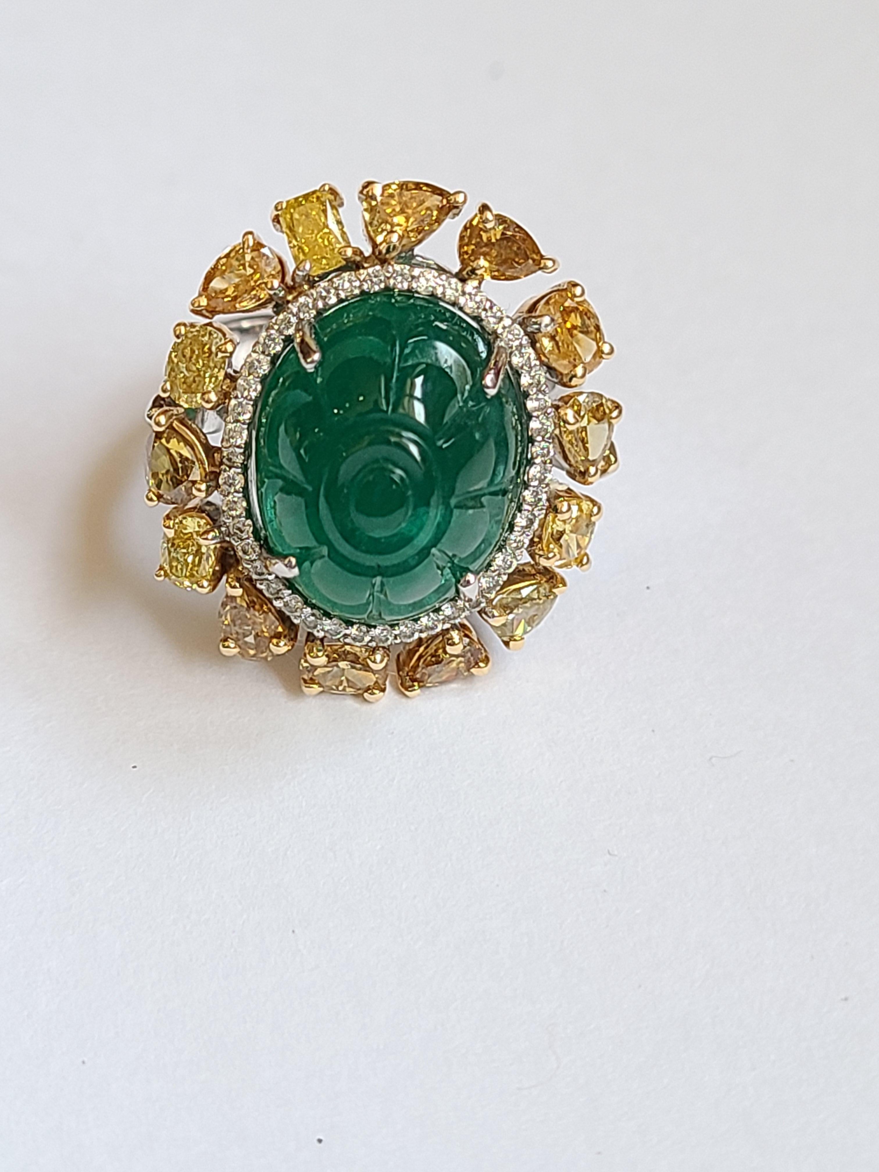 A beautifully carved natural emerald ring set in 18k gold with natural fancy color diamond. The emerald is natural and weight is 10.20 carats , diamond weight is 2.22 carats.  ring dimension in cm 2 x 1.8 x 3 (LXWXH) . US size 6 1/2.
