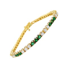 Bracciale tennis alternato con smeraldo naturale e diamante in oro giallo 18 carati