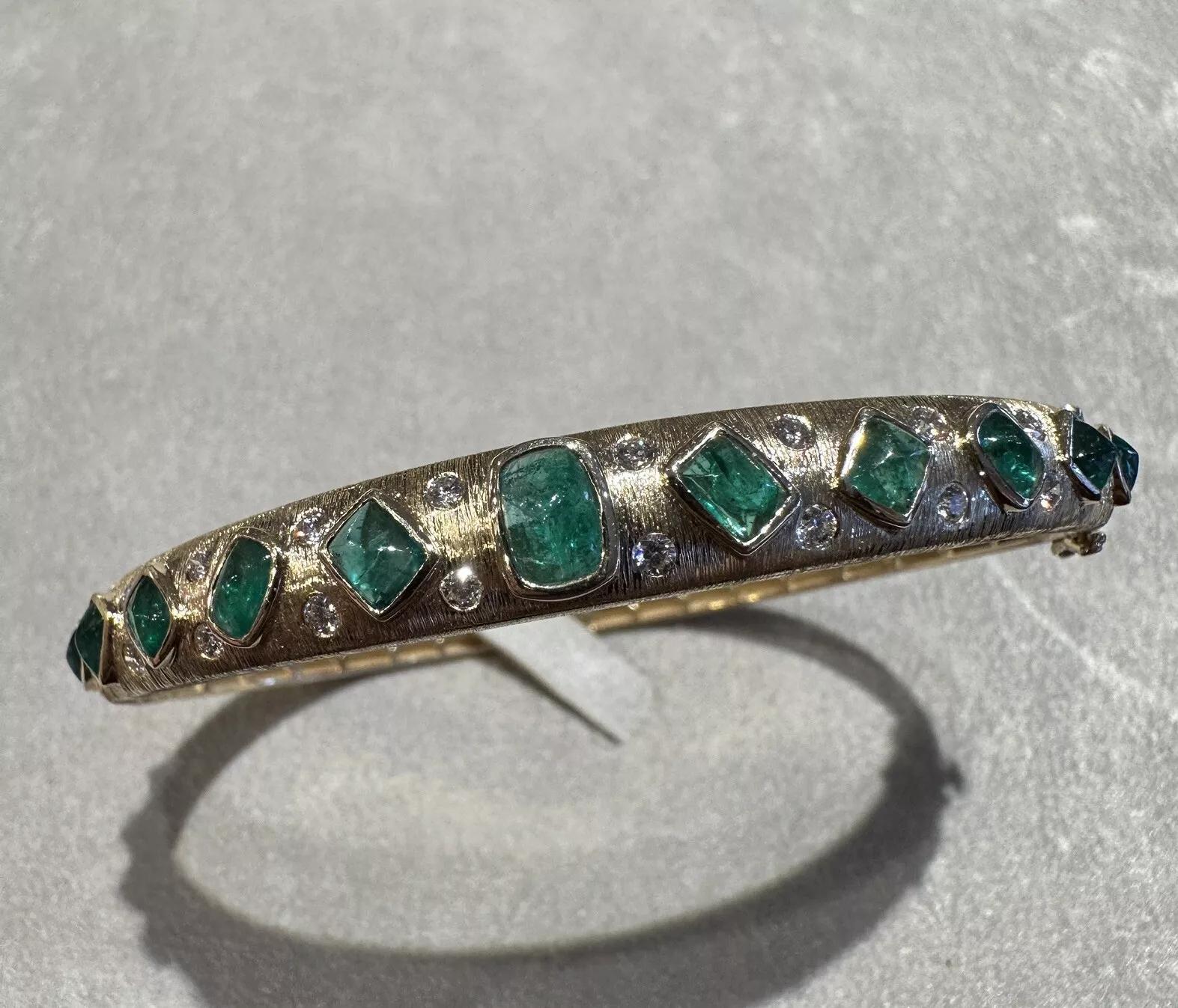 Emerald and Diamond Hinged Bangle Bracelet in Textured 14k Yellow Gold 

14K Textured Yellow Gold Bracelet features 12 Cabochon Emeralds and 24 Round Brilliant cut Diamonds bezel set on top half of bracelet. The oval-shaped bangle has a hinged