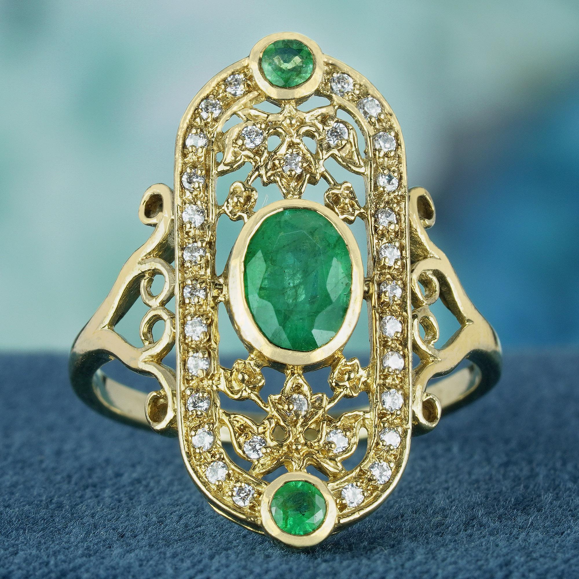 Crafted from luminous yellow gold, this ring boasts a slim band adorned with intricate scrollwork on the shoulders. The focal point of the design is a large oval emerald, accents by two smaller round emeralds positioned at the top and bottom of the