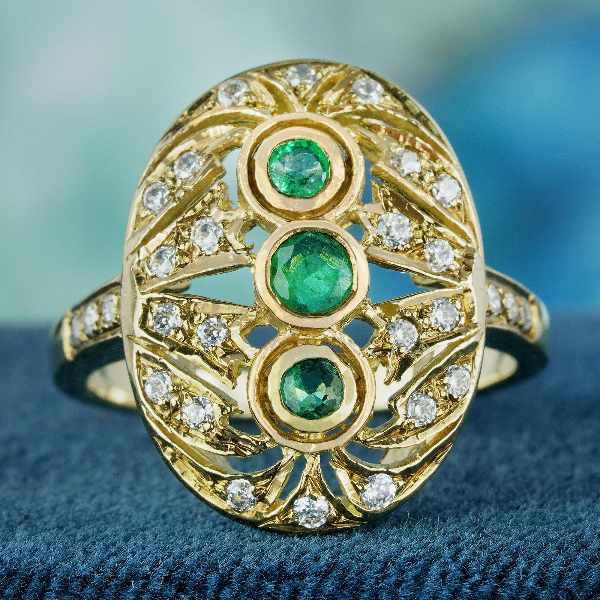 Das Herzstück dieses Rings sind drei faszinierende Smaragde im Rundschliff. Dieser ovale, filigrane Ring aus strahlendem Gelbgold im Vintage-Stil strahlt zeitlose Eleganz aus. Die Schultern des Bandes sind mit Diamanten verziert und verleihen ihm
