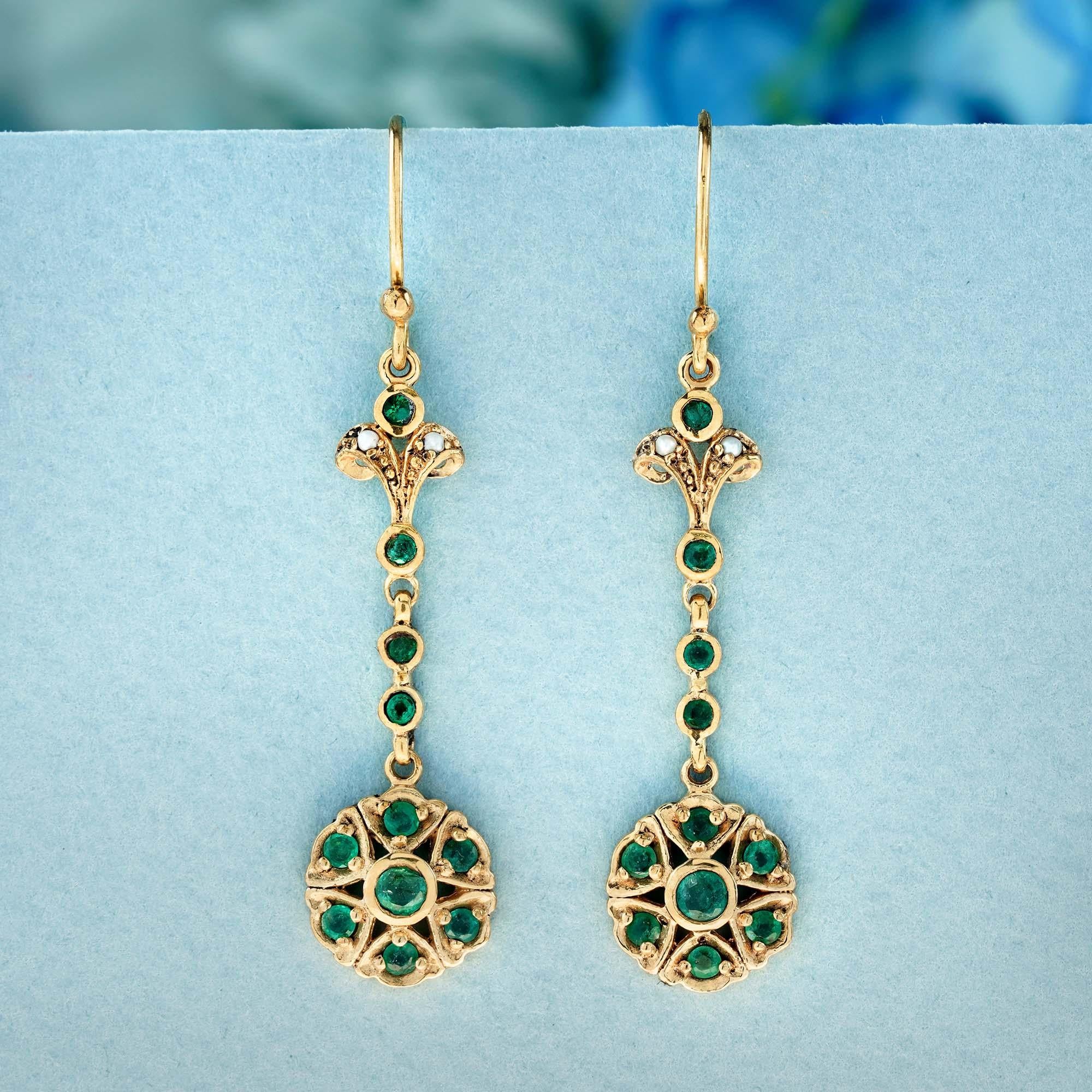 These dangling earrings draw inspiration from vintage aesthetics. They showcase a delicate chain adorned with round green emeralds, gracefully cascading from a bezel-set round emerald flower in a yellow gold frame. The design concludes with an