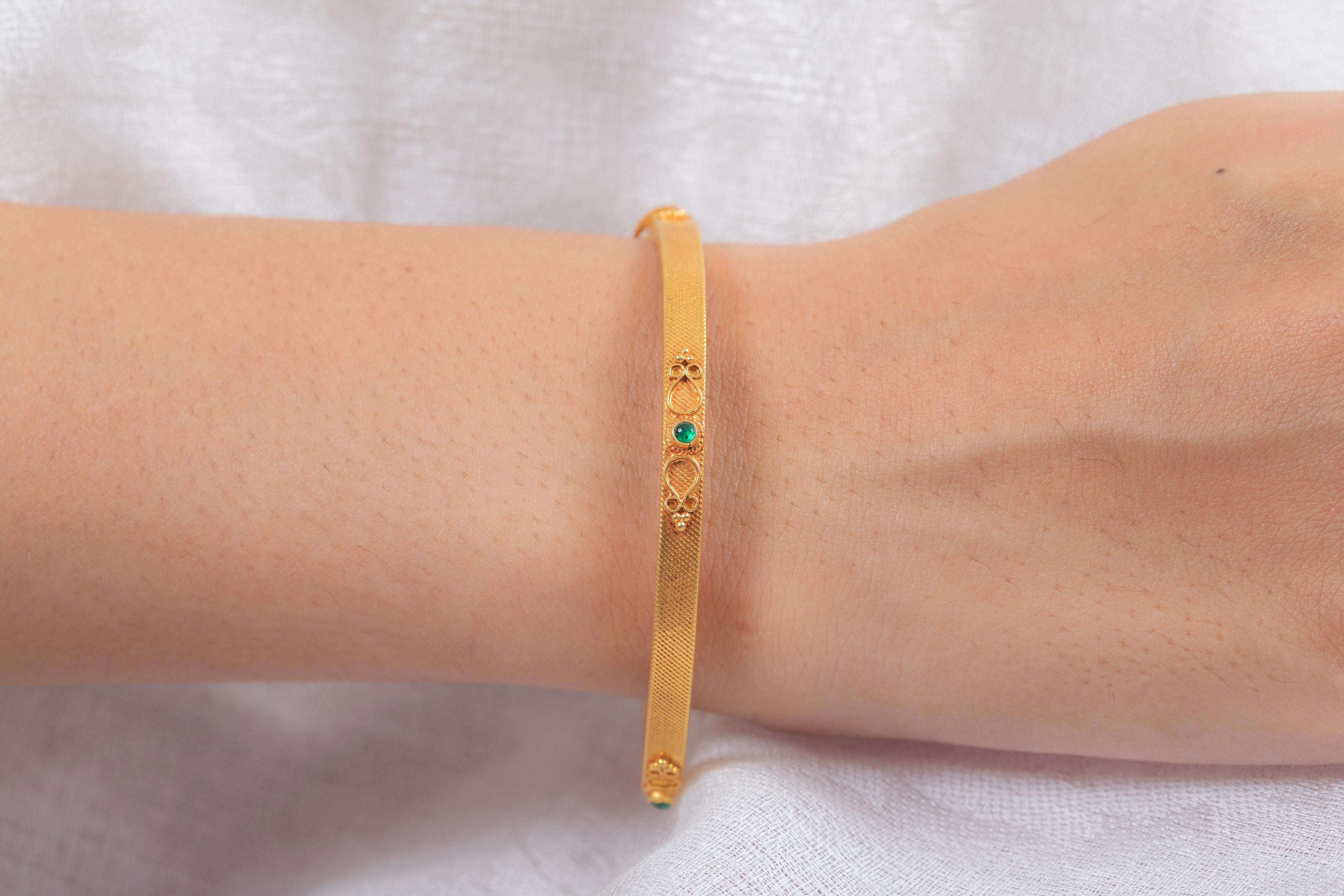 Emerald Bangle with a traditional engraving on it in 18K Gold. It’s a great jewelry ornament to wear on occasions and at the same time works as a wonderful gift for your loved ones. These lovely statement pieces are perfect generation jewelry to
