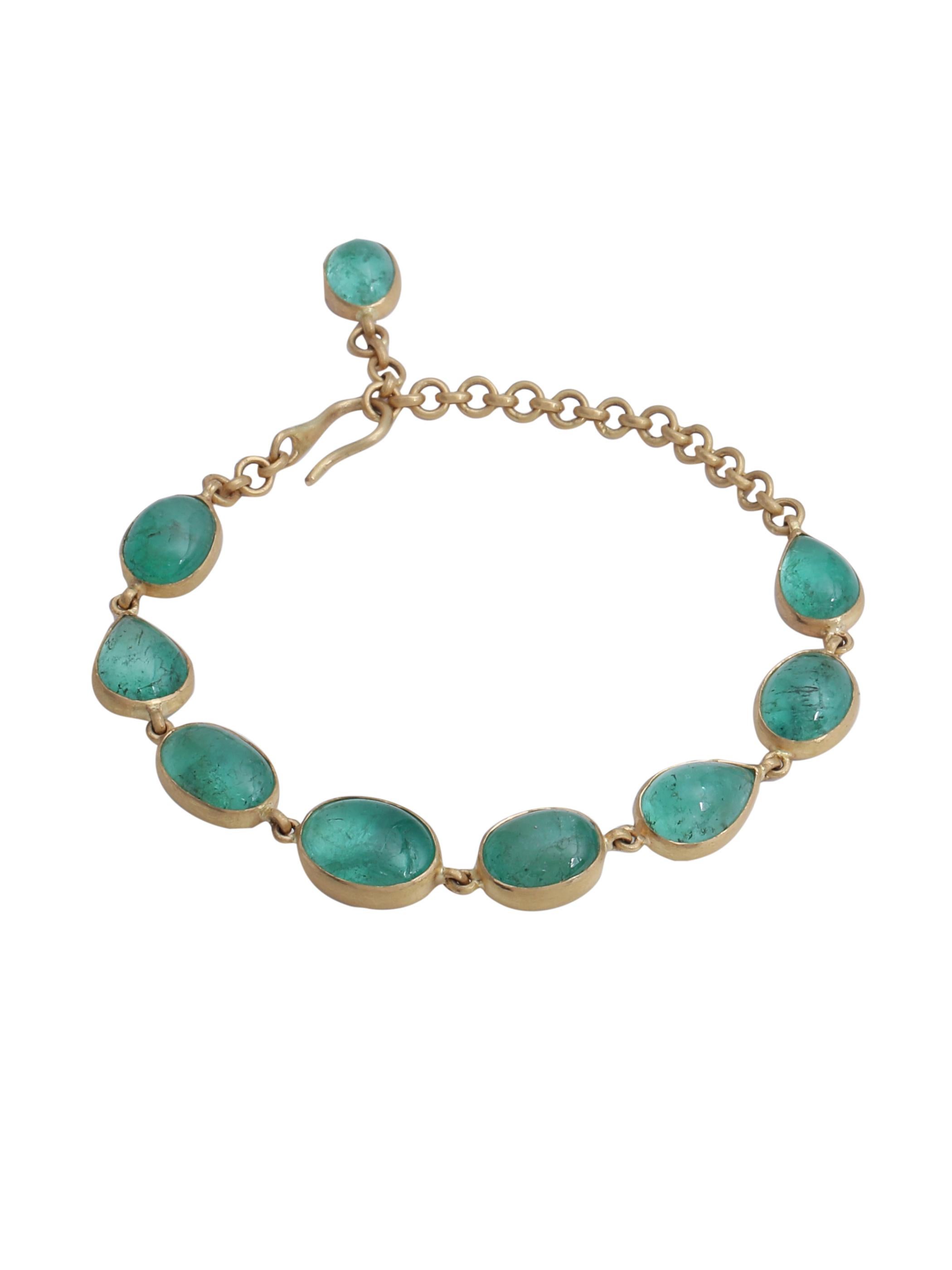 Una preciosa pulsera con cabujones de esmeralda natural hecha a mano en oro amarillo de 22 quilates acabado mate. El acabado del oro complementa y realza el color de las esmeraldas.
Puedes ver un pequeño cabujón de esmeralda colgando en el extremo