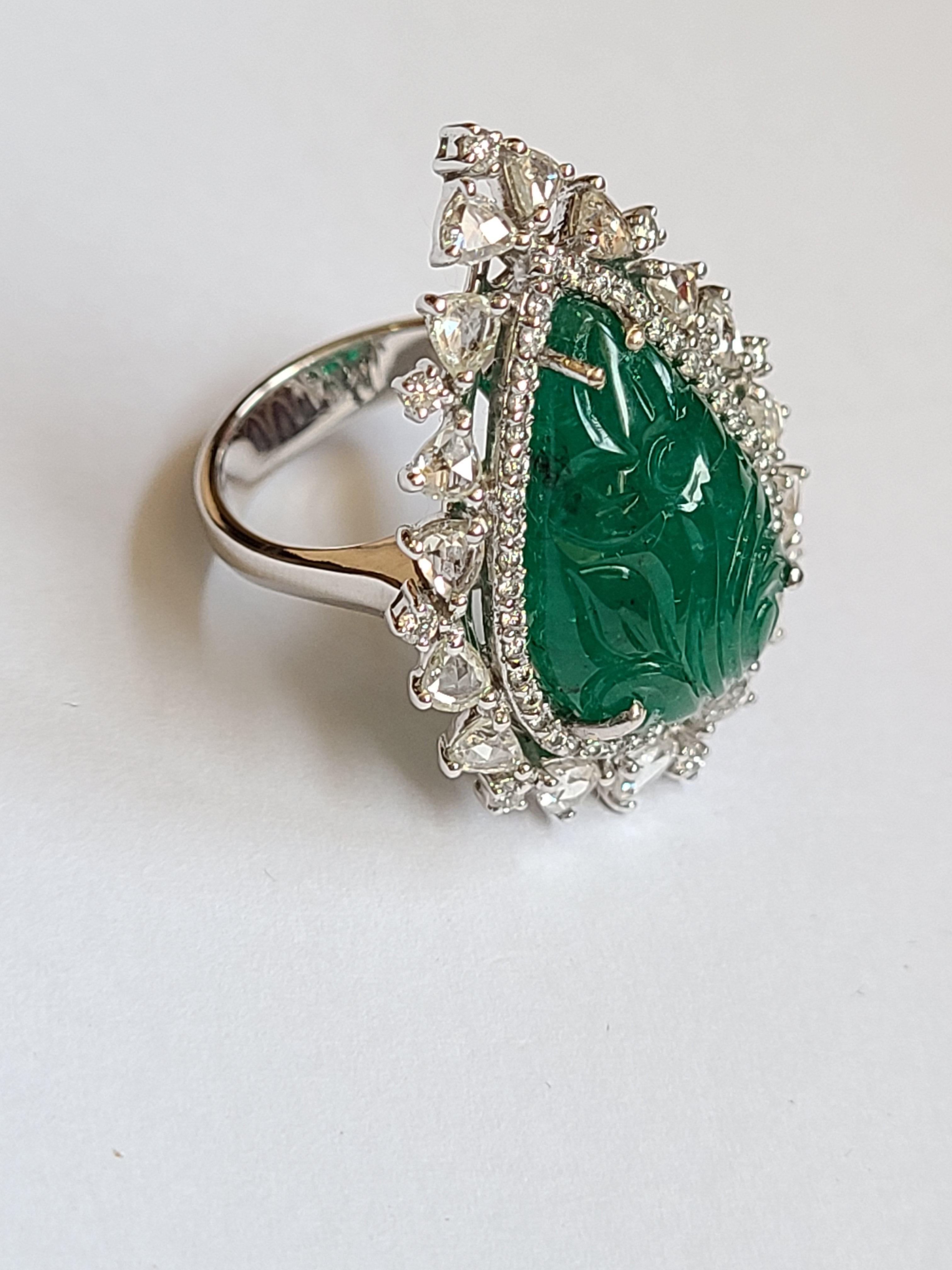 A beautiful and classic Emerald carving ring set in 18k gold with fullcut and rosecut diamonds. the emerald weight is 12.44 carats . The ring dimensions in cm 3.3 x 1.7 x 2.5 (LXWXH). US size 6