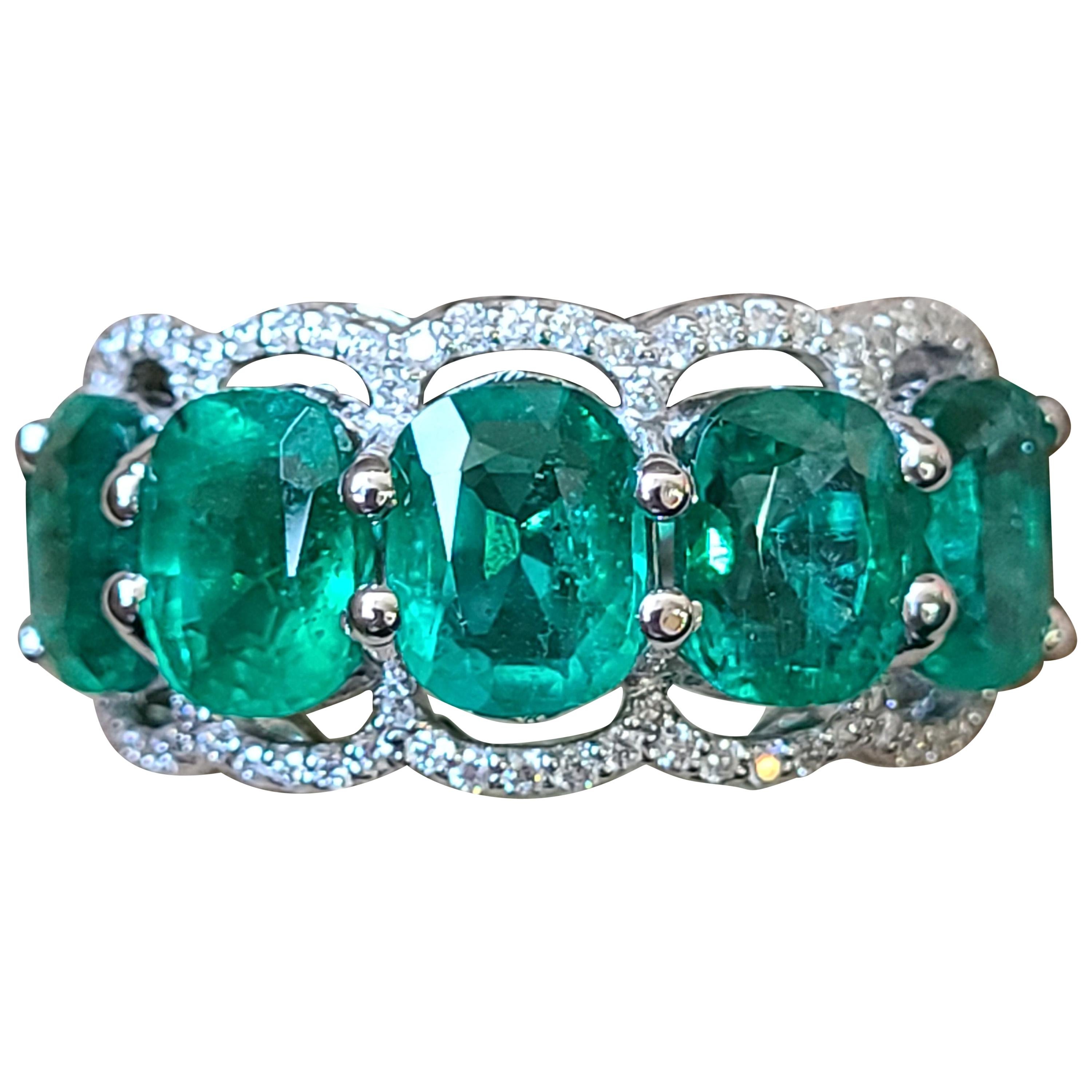 A modern and chic 5 piece natural emerald with diamonds set in 18k gold . The Emerald is natural and originates from Zambia. Weight of emerald is 5.28 carats and diamond weight is .30 carats. The ring dimensions in cm 1.1 x 3 x 2.2 (LXWXH) . US size