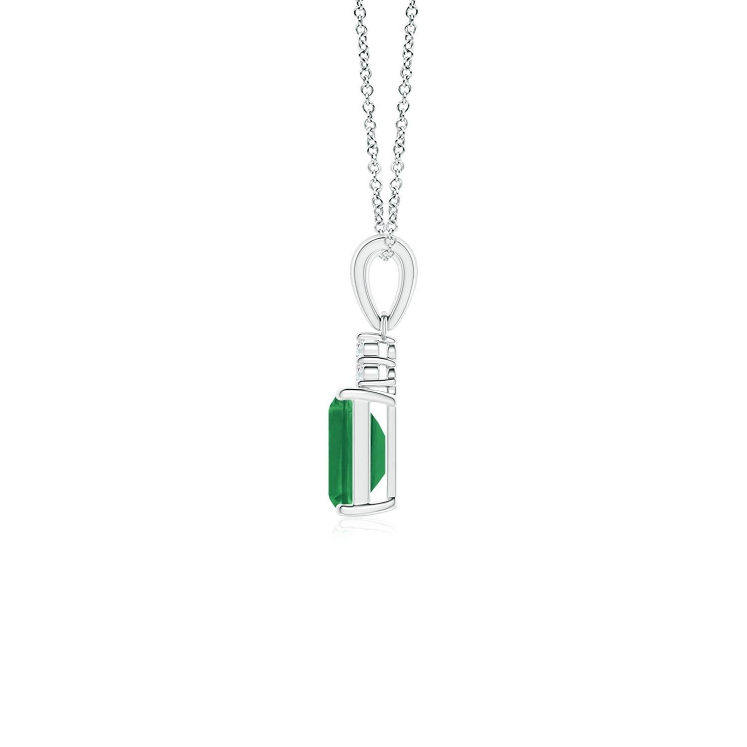 A stunning emerald-cut emerald sits pretty in a four-prong setting, topped by a glimmering cluster of diamonds. The rich green gemstone is enhanced by the brilliance of the sparkling white diamonds. This exquisite emerald dangle pendant is an