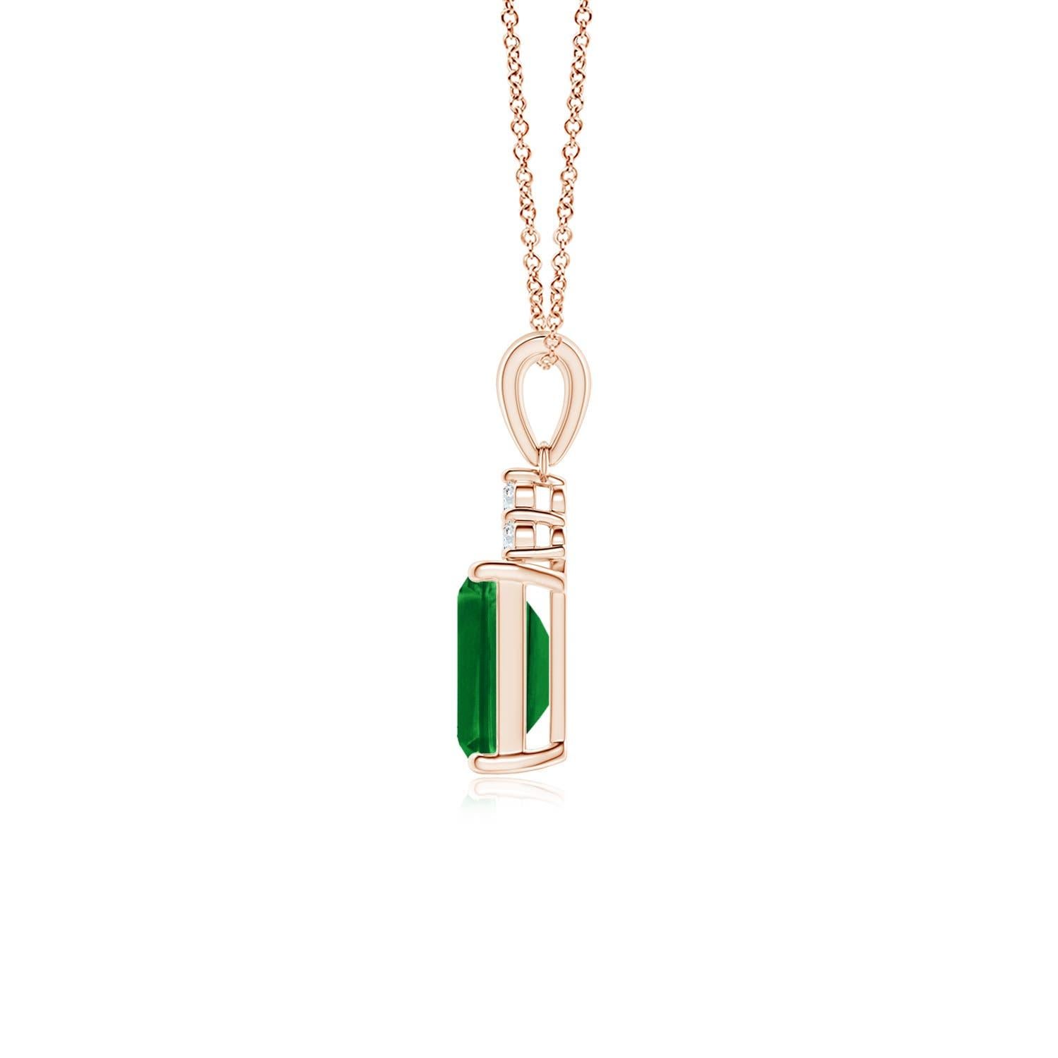 A stunning emerald-cut emerald sits pretty in a four-prong setting, topped by a glimmering cluster of diamonds. The rich green gemstone is enhanced by the brilliance of the sparkling white diamonds. This exquisite emerald dangle pendant is an