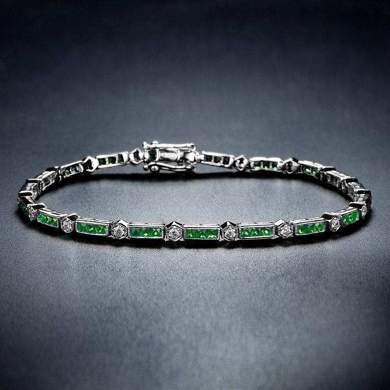 Dieses luxuriöse und farbenfrohe Armband von Aimée ist abwechselnd mit dreifachen Baguette-Smaragden und runden Diamanten im Brillantschliff besetzt. Das 18-karätige Weißgold verleiht dem klassischen Art-Deco-Stil Sicherheit, und ein