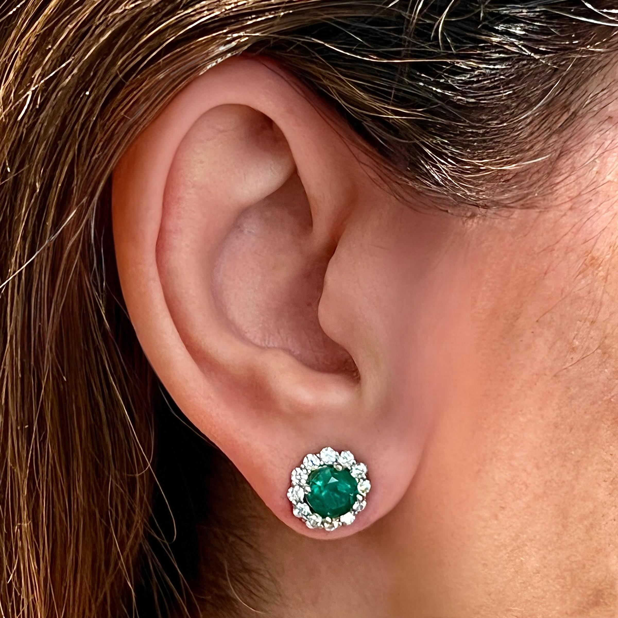 These Magnificent Natural Finely Faceted Quality Emerald and White Diamond Halo Earrings are a luxurious addition to any fine jewelry collection.

Each earring features a vibrant, finely faceted natural emerald at the center, framed by a stunning