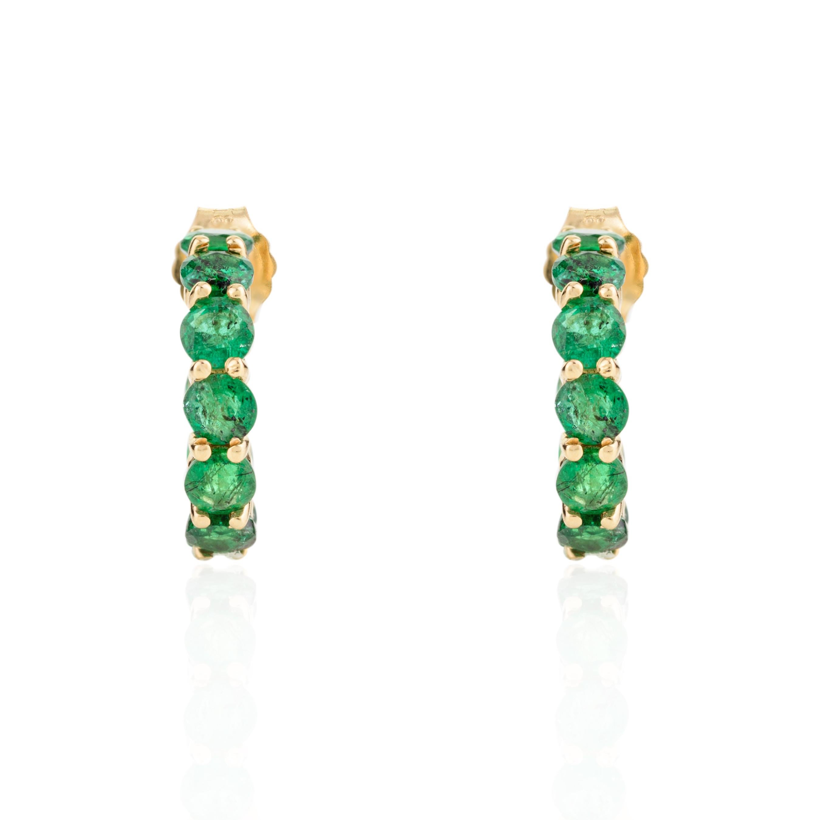 Natürlicher Smaragd Everyday Huggie Hoop Earrings in 18K Gold, um Ihren Look zu unterstreichen. Sie brauchen Ohrstecker, um mit Ihrem Look ein Statement zu setzen. Diese Ohrringe mit rundgeschliffenem Smaragd sorgen für einen funkelnden, luxuriösen