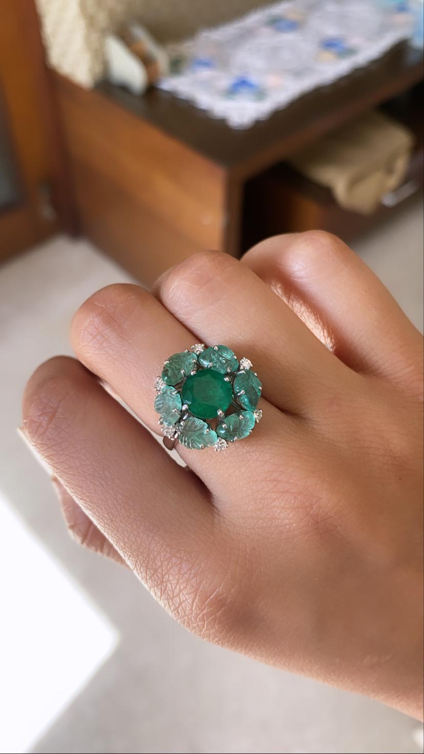 Un anillo moderno engastado en oro blanco de 18 quilates con esmeralda natural y diamante natural. El peso de la esmeralda central es de 2,18 quilates y el de la esmeralda tallada que rodea al centro es de 2,95 quilates, el peso del diamante es de