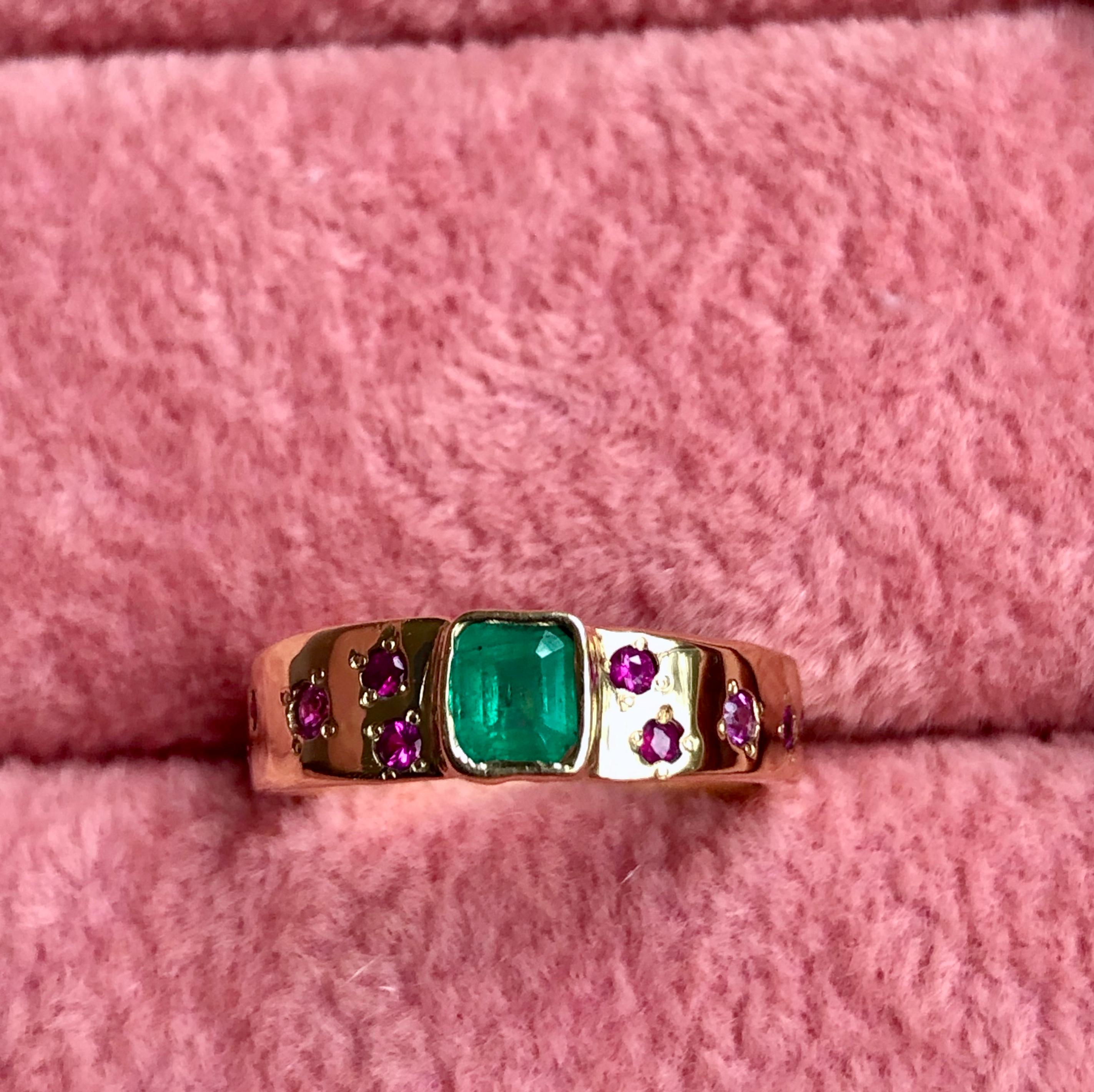 Finely detailed and perfectly imperfect, this one-of-a-kind band is exquisite, yet simple, combination of vibrant Colombian emerald and rubies rich 18K pinkish-yellow gold. Celebrate an anniversary or represent a commitment with this ring on your