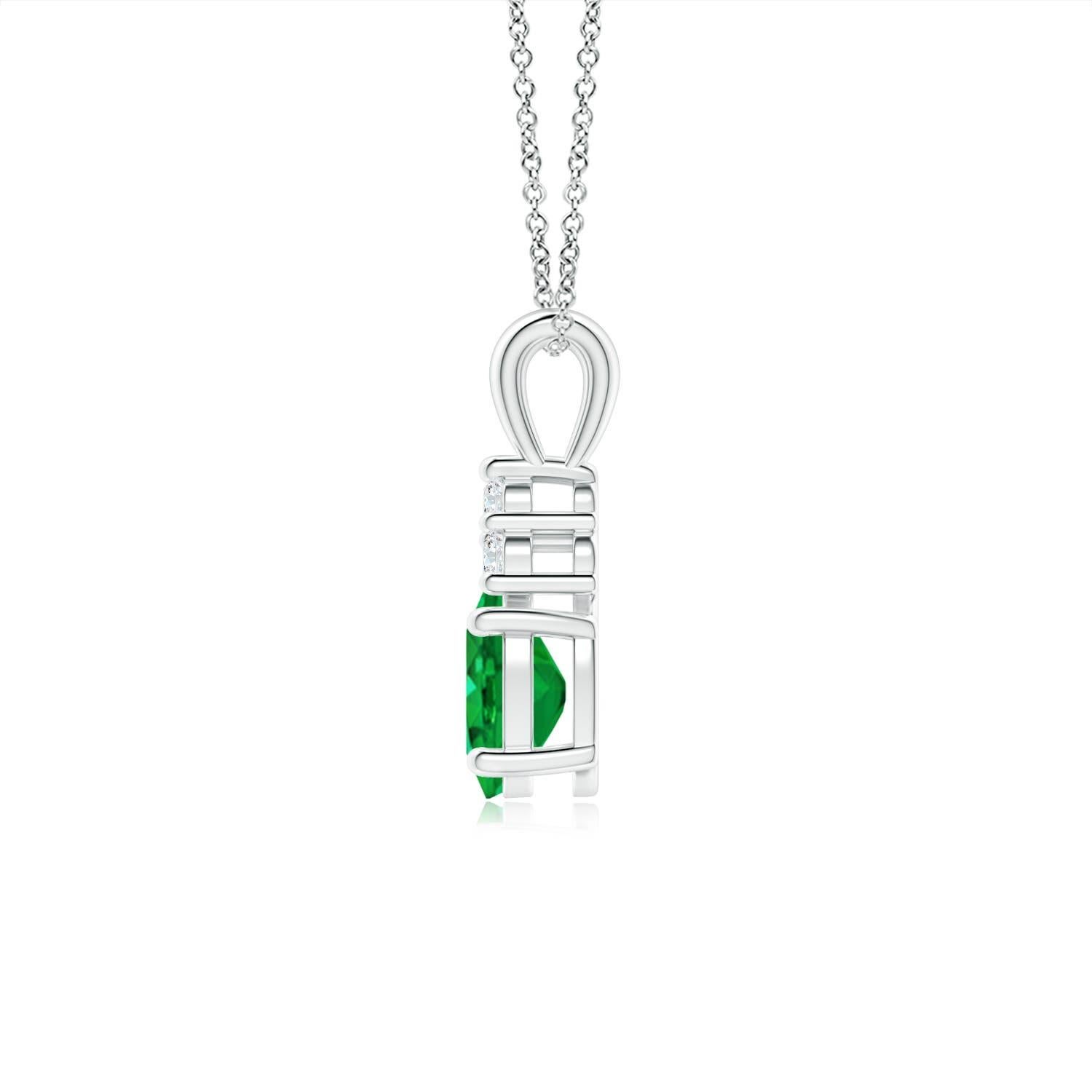 Set in platinum, this classic solitaire emerald pendant showcases the perfect blend of style and elegance. It features a lush green emerald adorned with three sparkling round diamonds on the top. Linked to a lustrous v-bale, this four-prong set